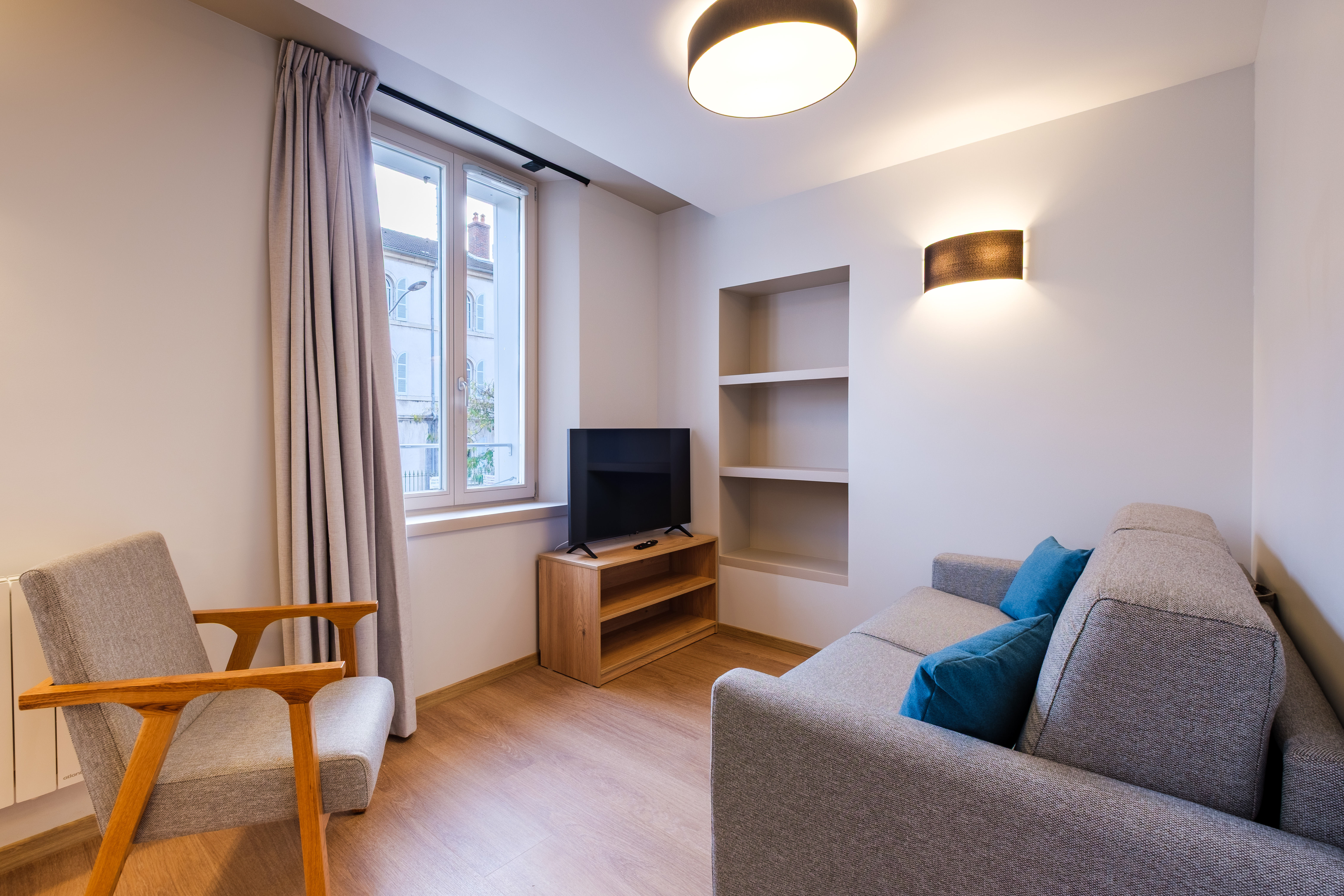 image The bright living area features a cosy sofa bed, a stylish TV stand, and soft accent pillows, perfect for relaxing or unwinding.