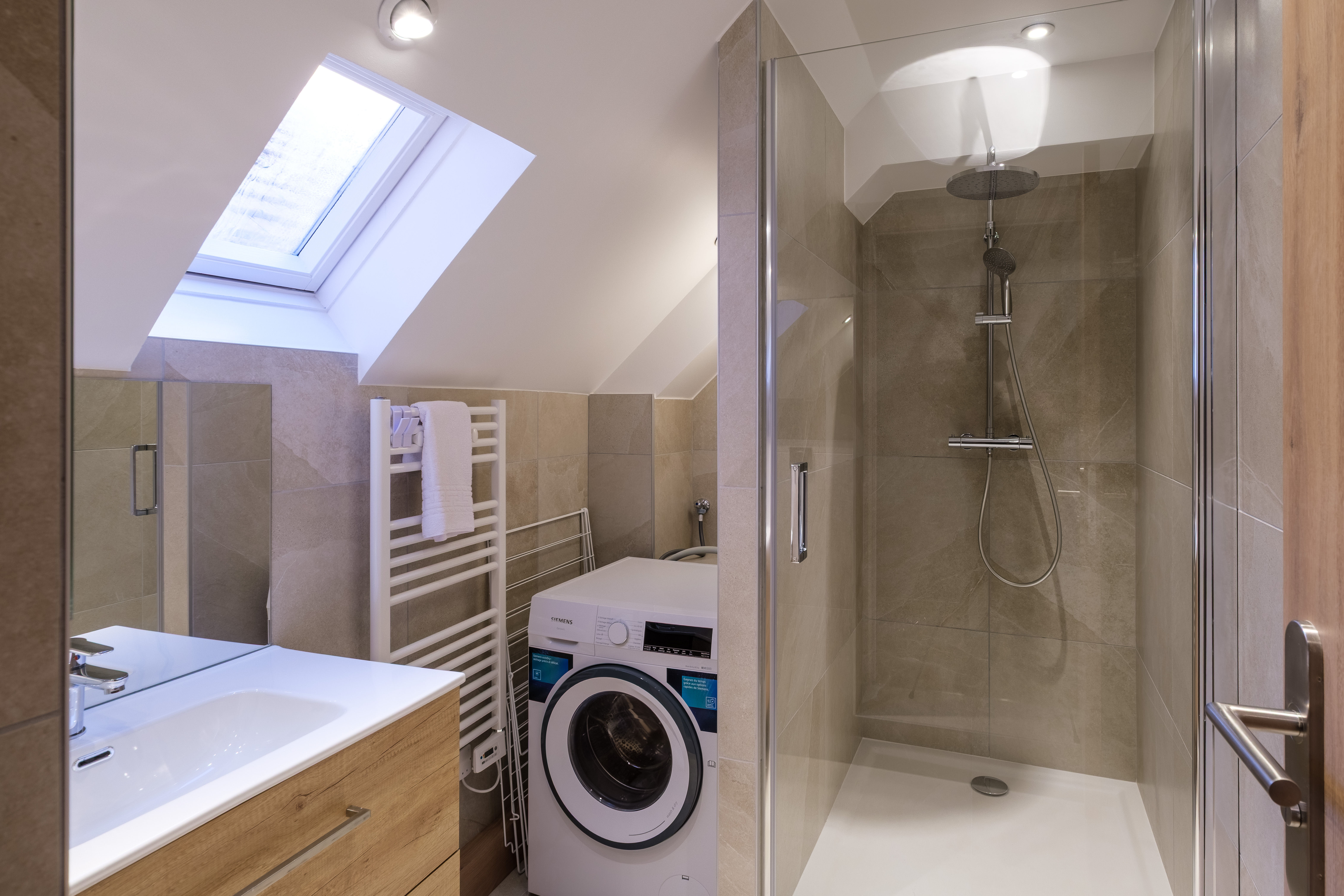 image The modern bathroom includes a sleek shower, contemporary finishes, and a washing machine for added convenience during your stay.