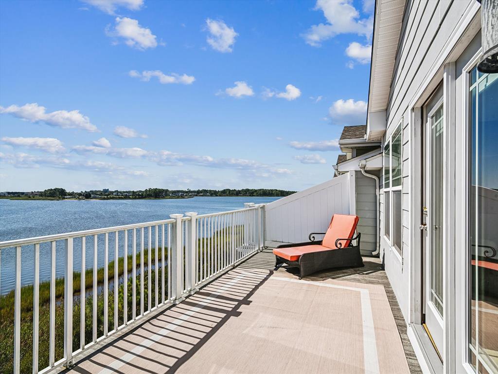 image Step out onto the balcony to enjoy open views of the water framed by greenery and open sky.