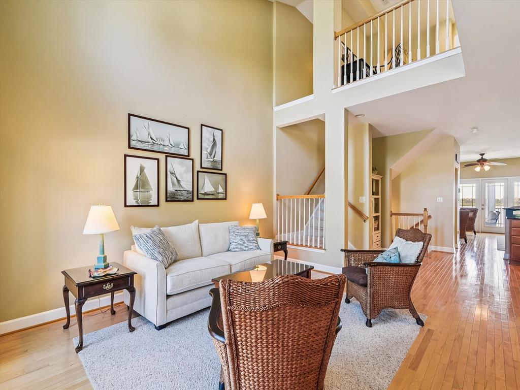 image The living area blends relaxed seating, framed coastal prints, and a staircase leading to the upper level.
