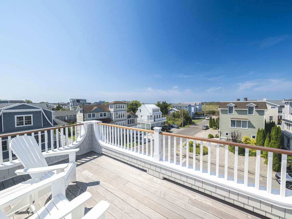 image Marvel at the vast blue skies and picturesque neighborhood from this charming outdoor seating area on the rooftop.