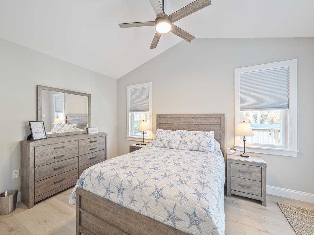 image The coastal-themed bedroom offers a cozy retreat with starfish-patterned bedding and a stylish wooden dresser.