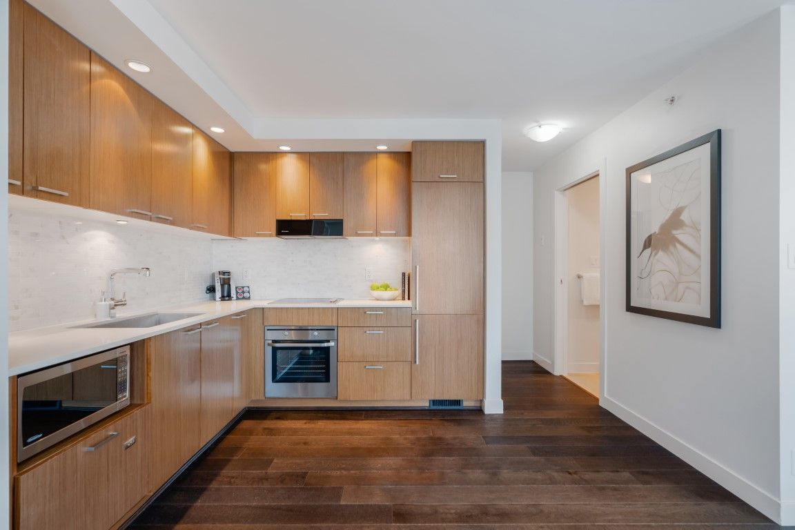 image The sleek kitchen, adorned with warm wooden cabinetry and contemporary appliances, provides an inviting space for culinary creativity and social gatherings.