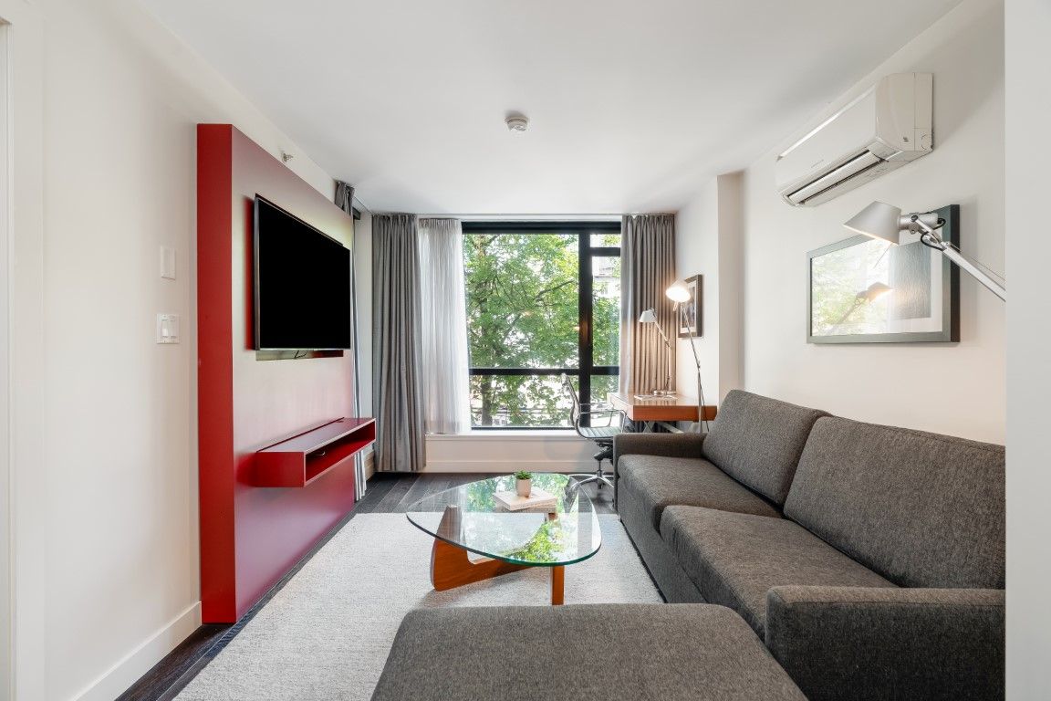 image This bright and inviting living area welcomes you with spacious seating, large windows offering views of greenery, and an efficient layout that ensures ease of movement.