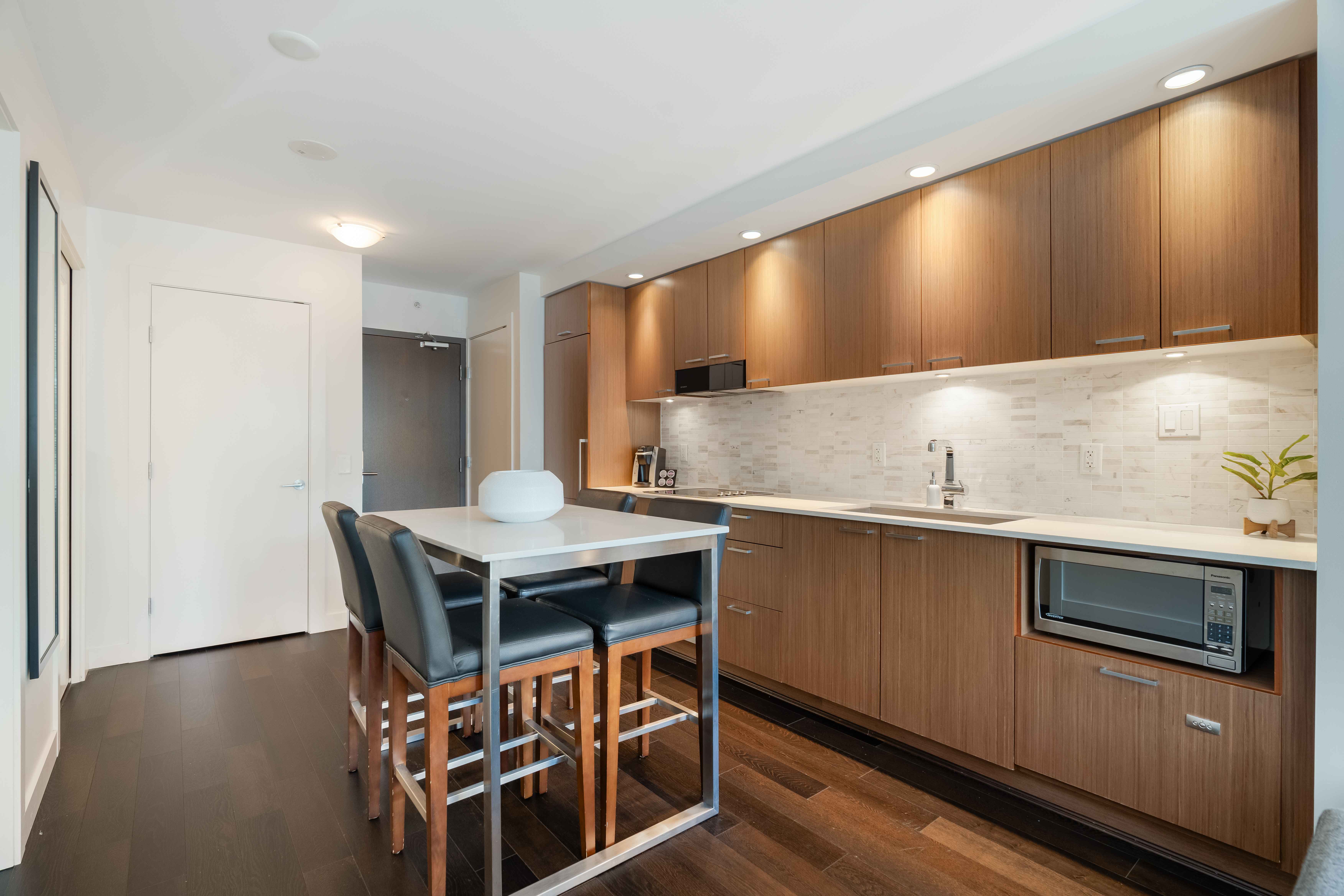 image Fully equipped modern kitchen with full-size appliances, sleek cabinetry, and a dining table for in-suite meals.