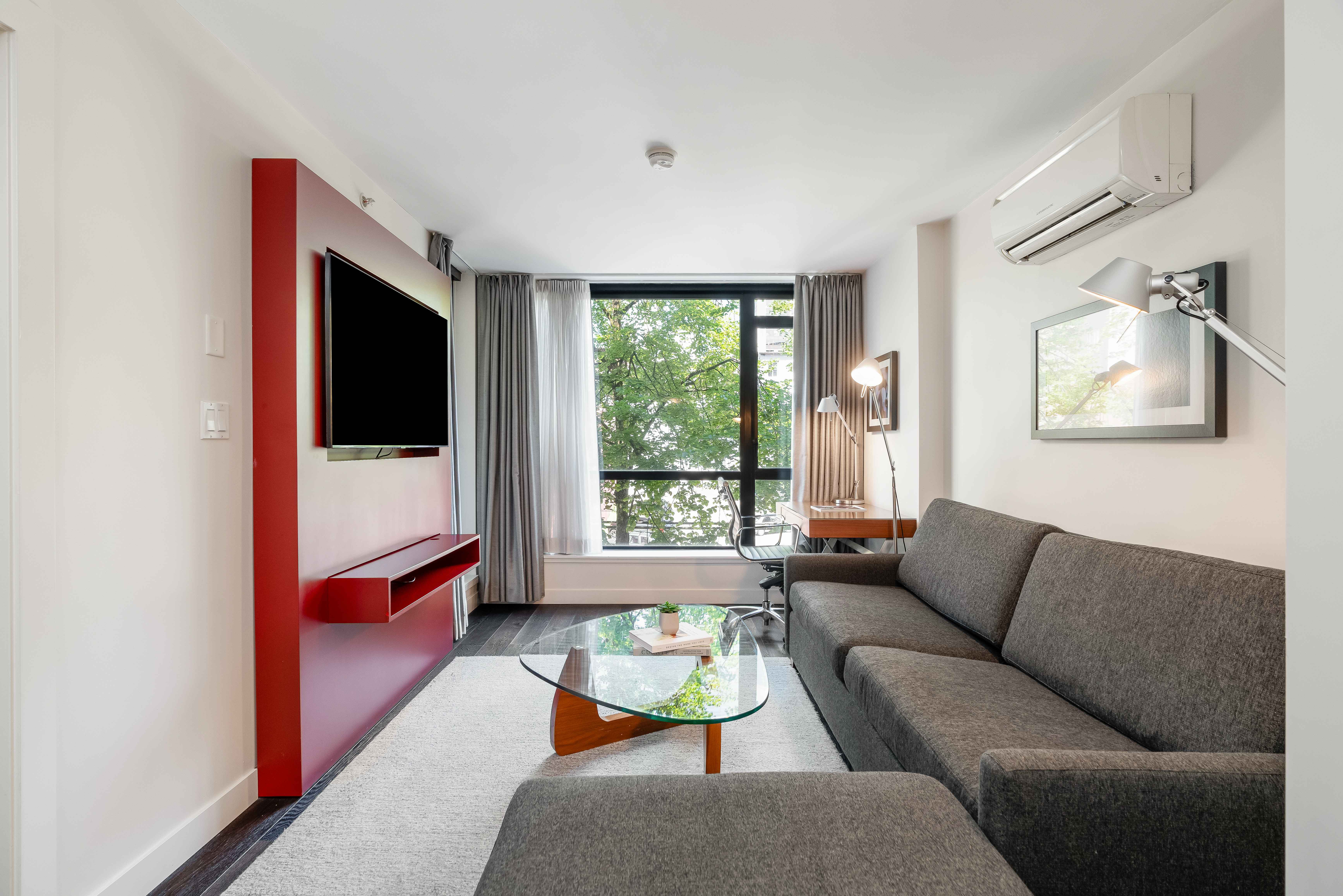 image Bright executive living area with a comfortable sofa, glass coffee table, and large windows bringing in natural light.