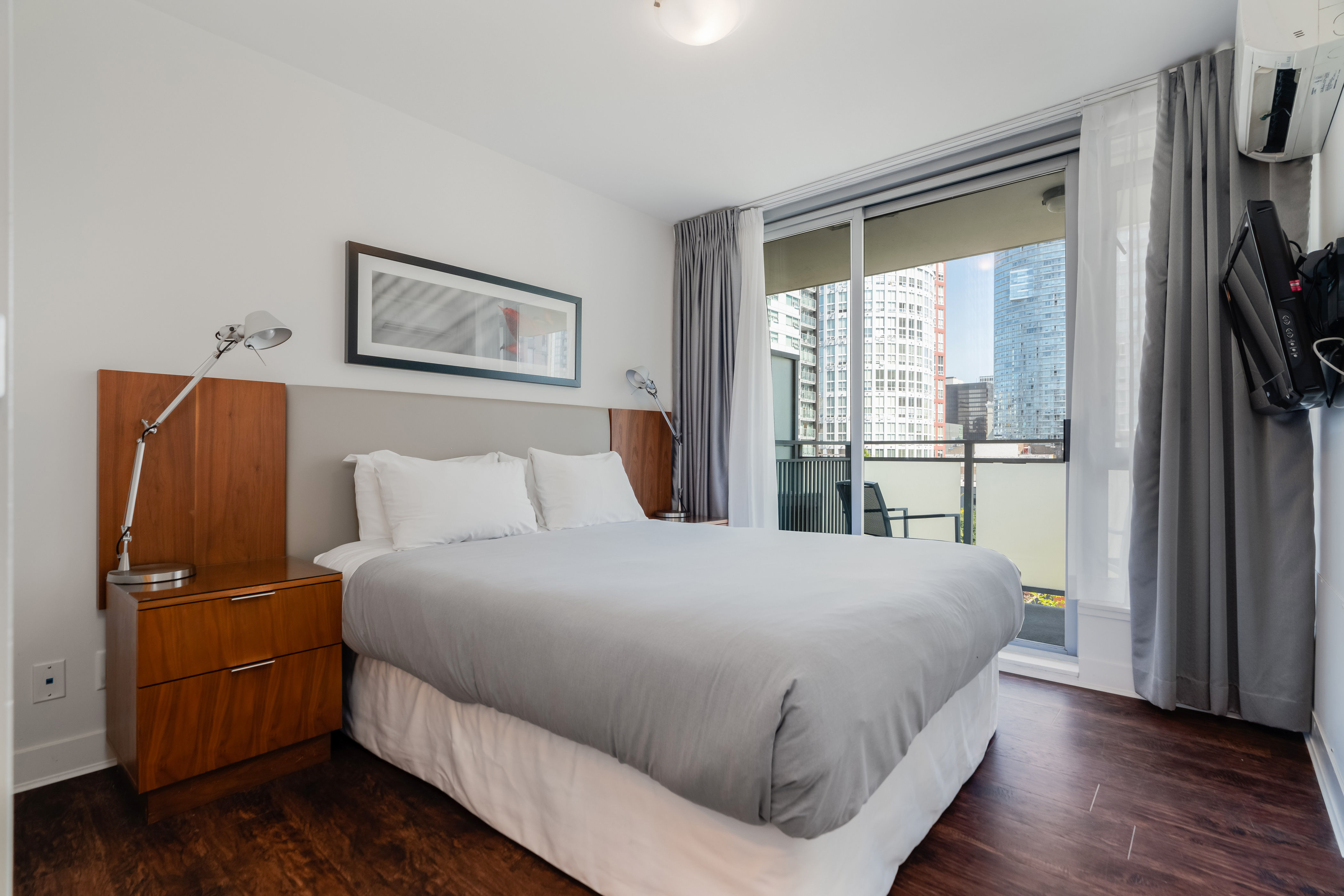 image The serene bedroom offers a tranquil escape with plush bedding, contemporary decor, and sliding doors that open onto a private balcony.