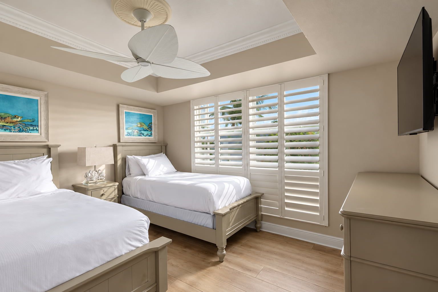 image Embrace tranquility in this serene guest room adorned with coastal art, where restful nights await in the Florida Keys.