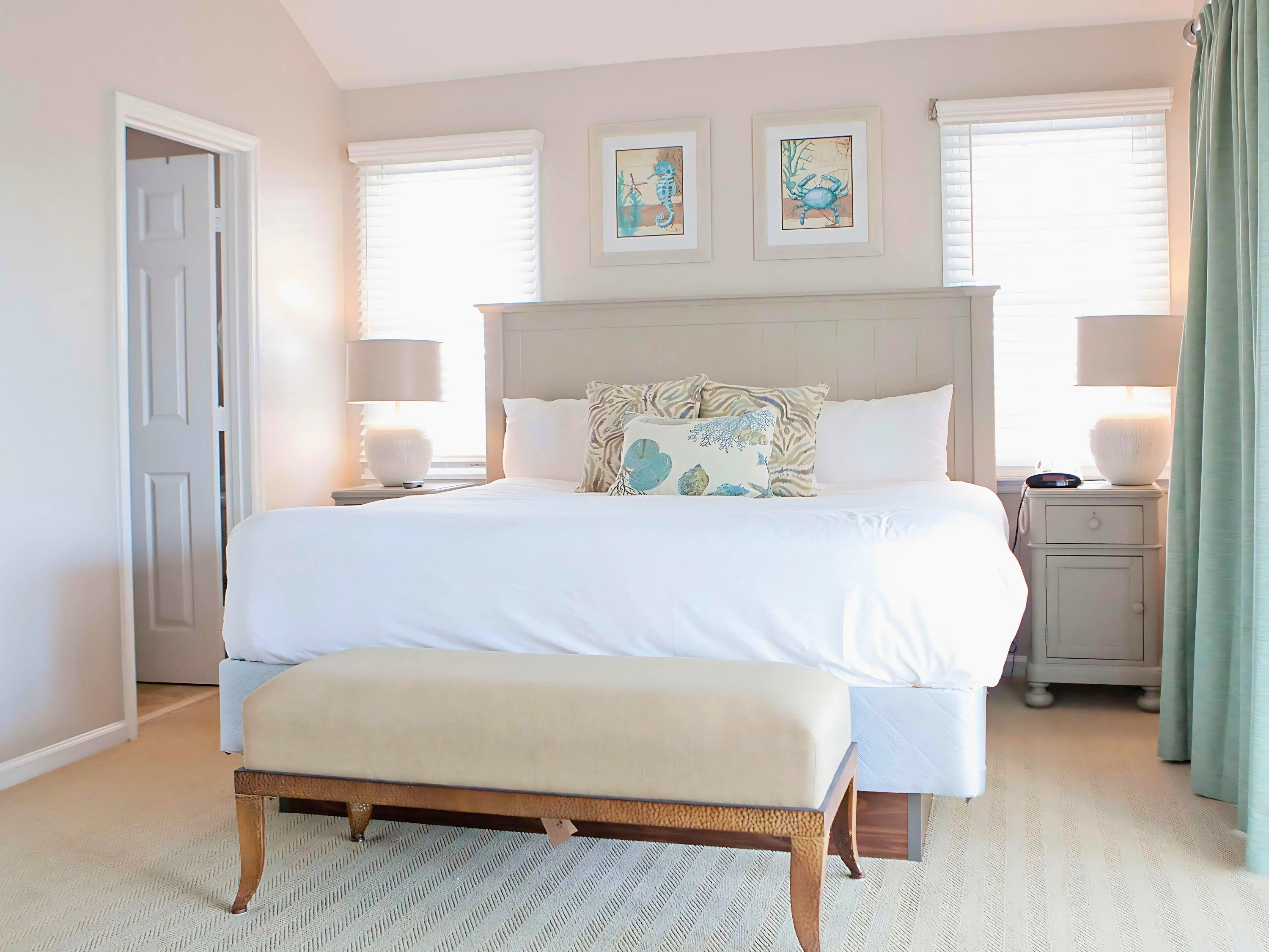 image Unwind in luxurious comfort with this dreamy bedroom, where coastal decor meets soothing colors for the perfect getaway retreat.