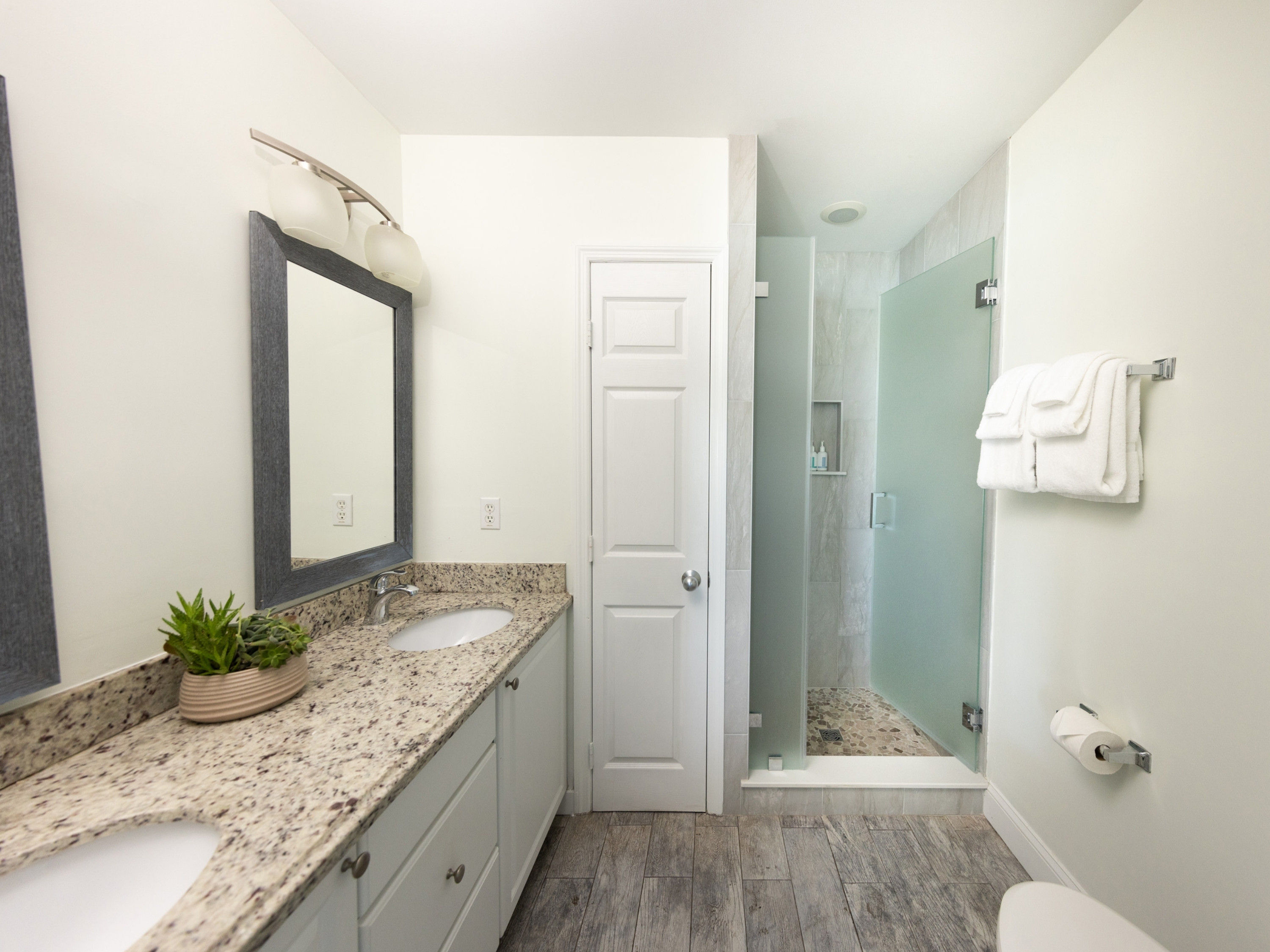 image Step into serenity with dual sinks and a luxurious shower in this elegantly designed bath, perfect for rejuvenation after sun-soaked adventures.