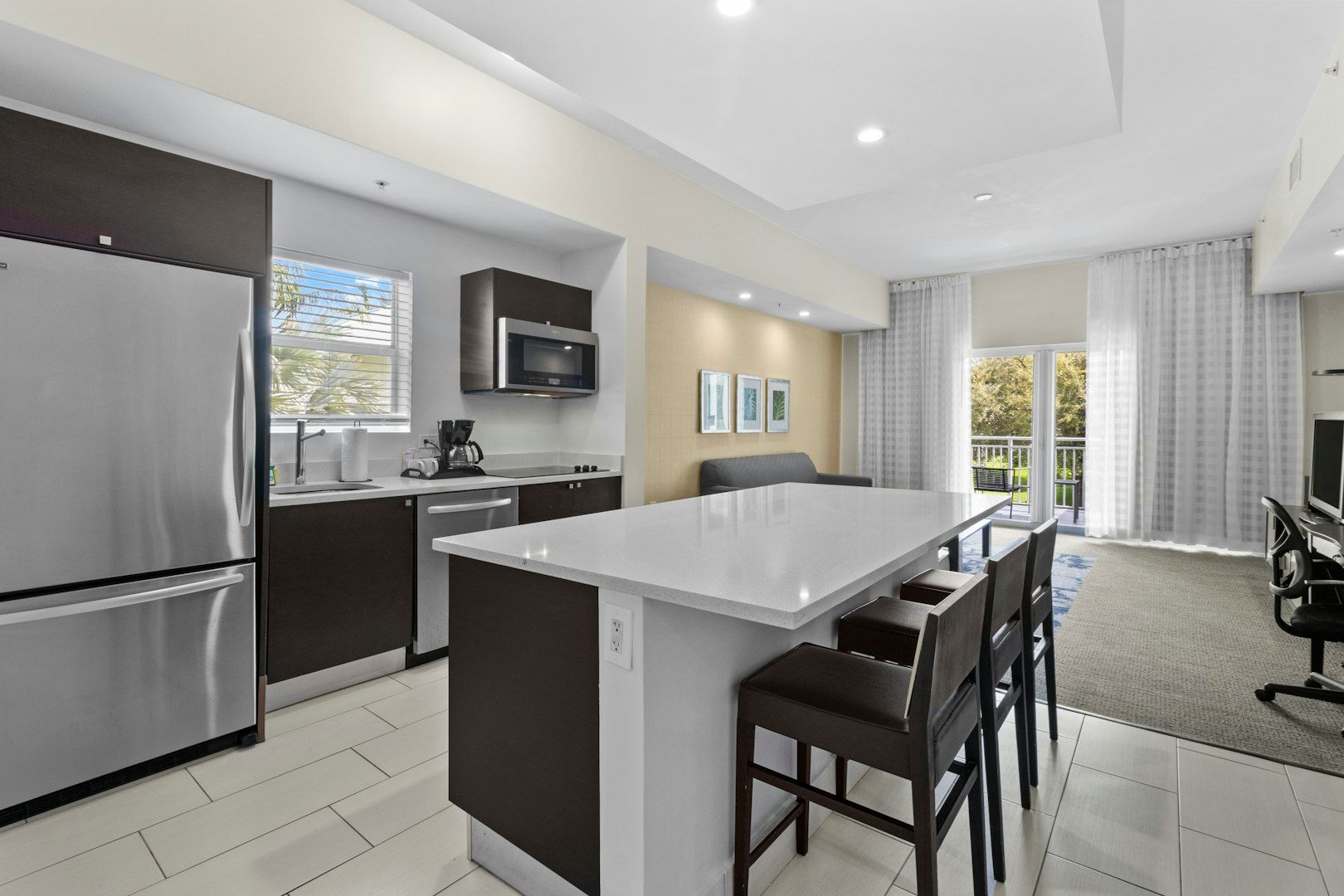 image Modern kitchen featuring a spacious island, stainless steel appliances, and seating for casual dining.