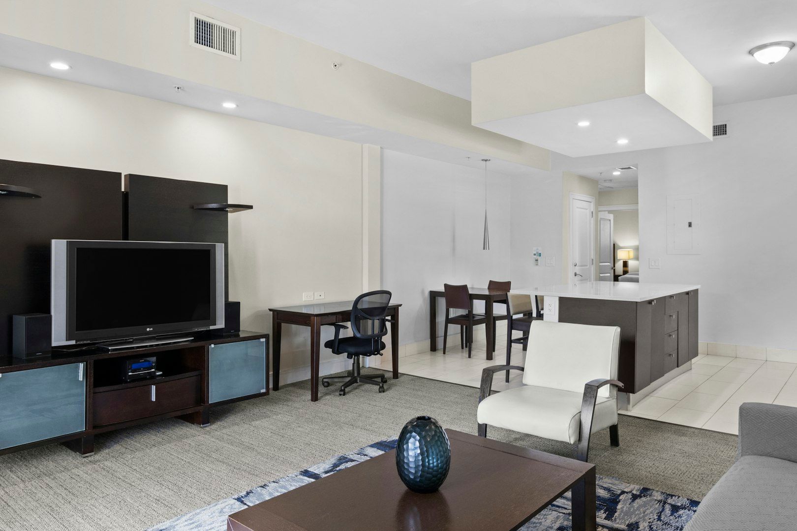 image Open living and dining area with a large TV, contemporary furnishings, and an easy-flow layout.