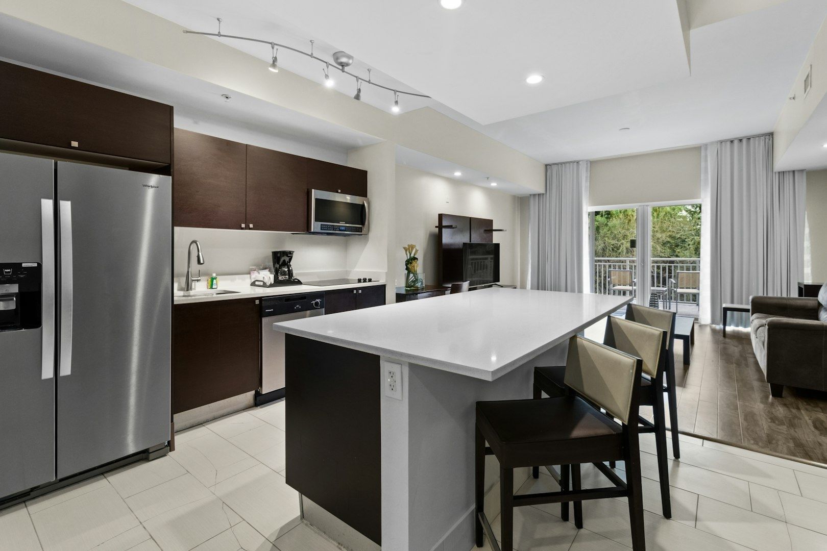 image Sunlit kitchen showcasing moderm cabinetry, granite countertop, and modern appliances.