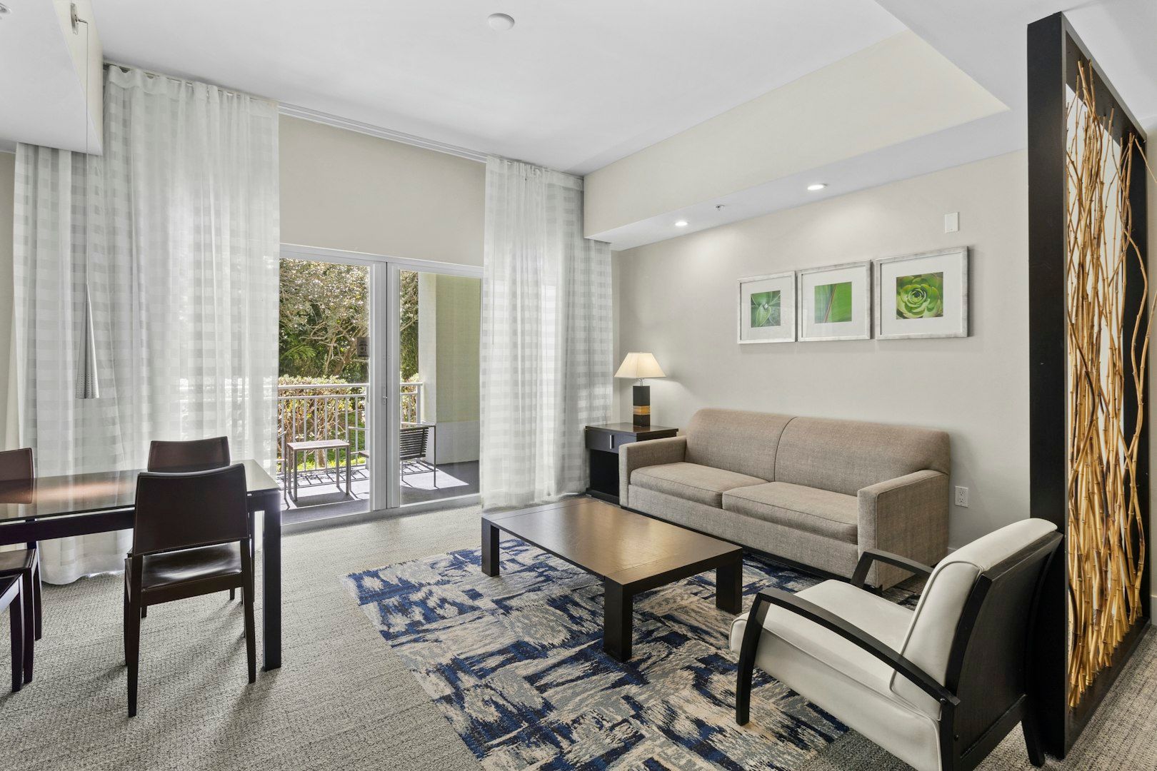 image Bright living and dining area with modern furnishings, an open layout, and natural light from the balcony doors.