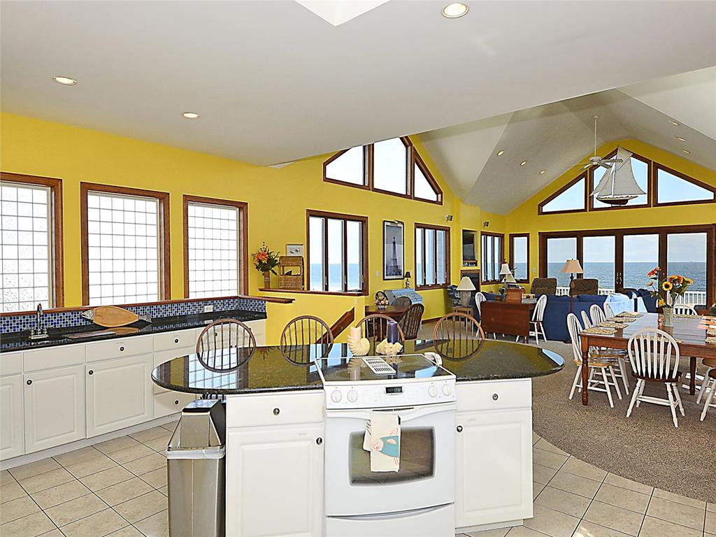 image Enjoy family dinners in this open-concept space, where coastal decor meets comfort.