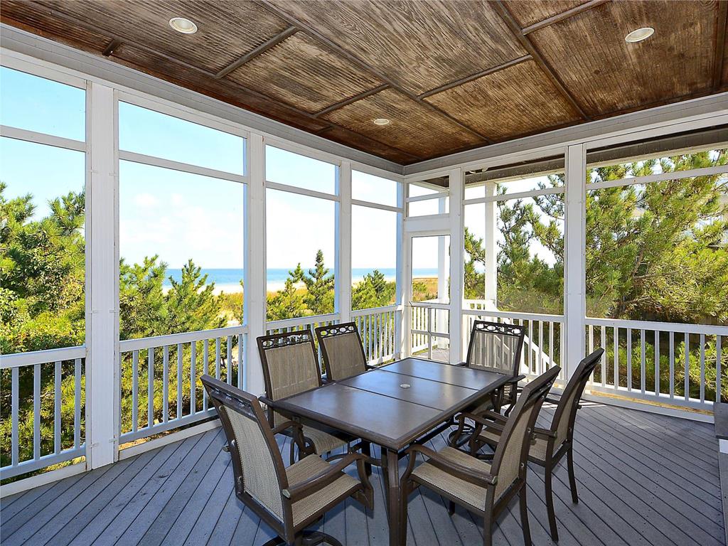 image Gather around the spacious table on the screen porch, catching ocean breezes and savoring each moment together.