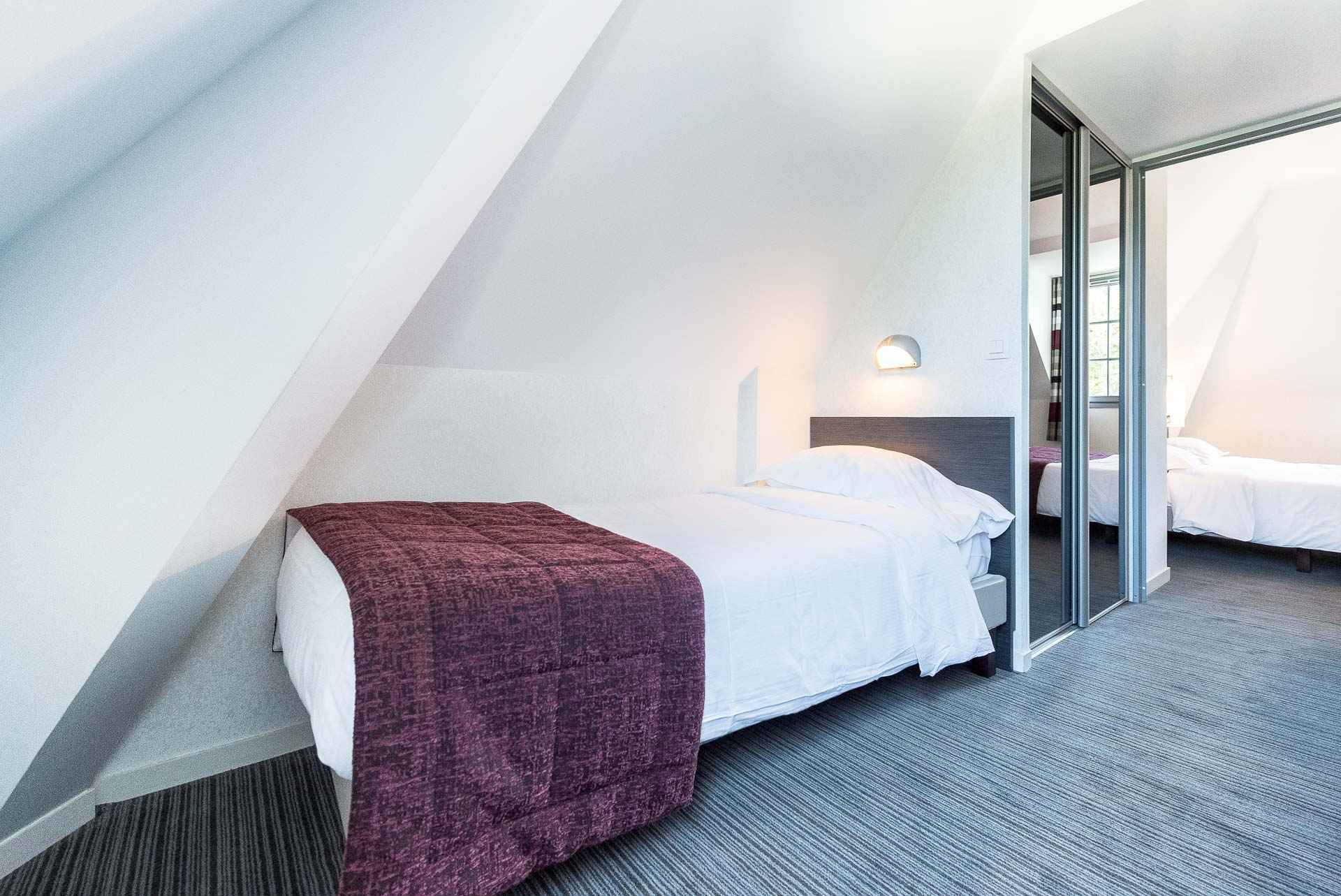 image Grey upholstered headboard, white linens, and a dining area in the background — a well-laid-out studio a short walk from Pont-Aven's galleries and the Aven river.