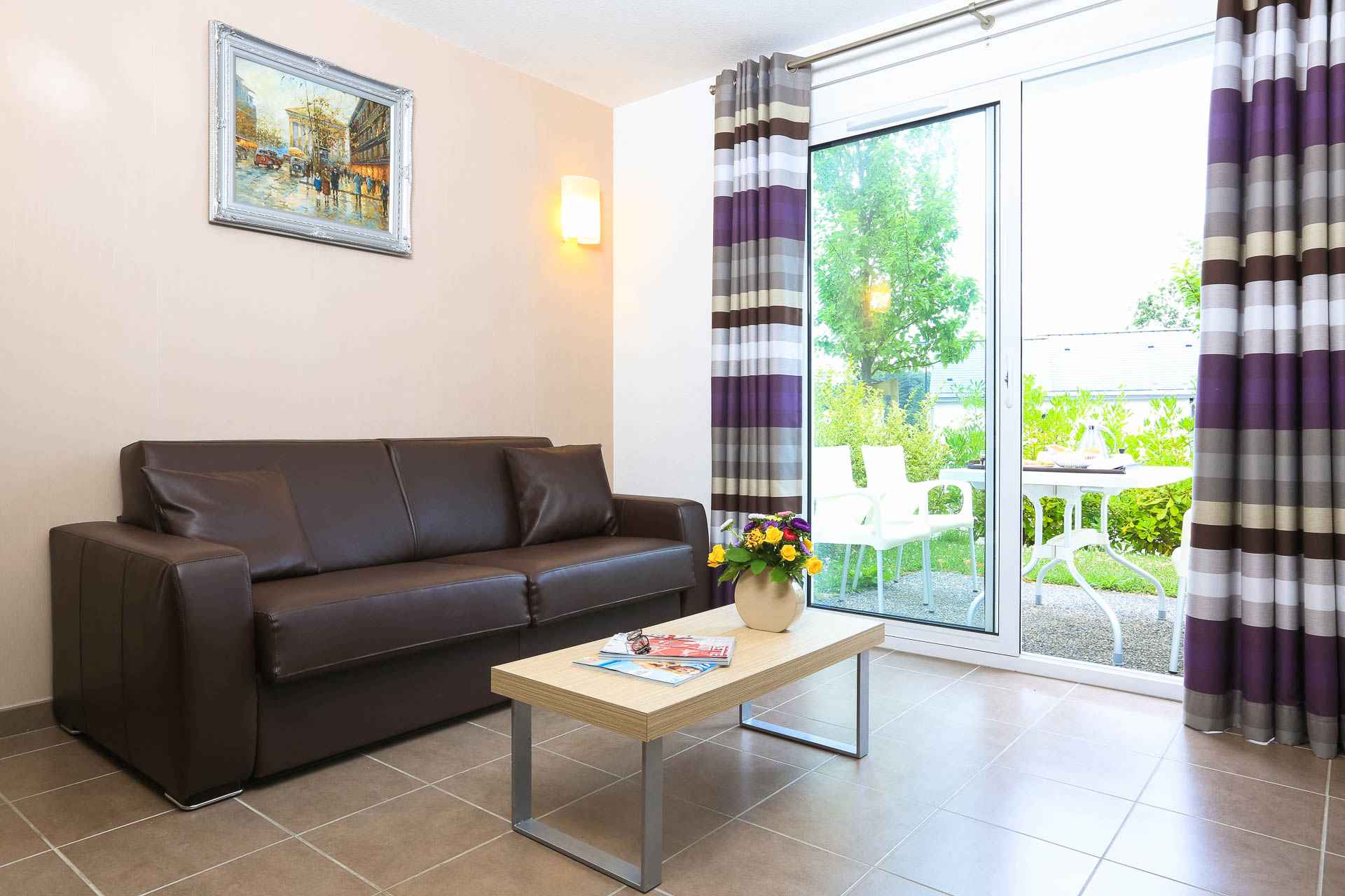 image Light-filled living area with warm furnishings and a bright colour palette — the sofa bed accommodates two extra guests.