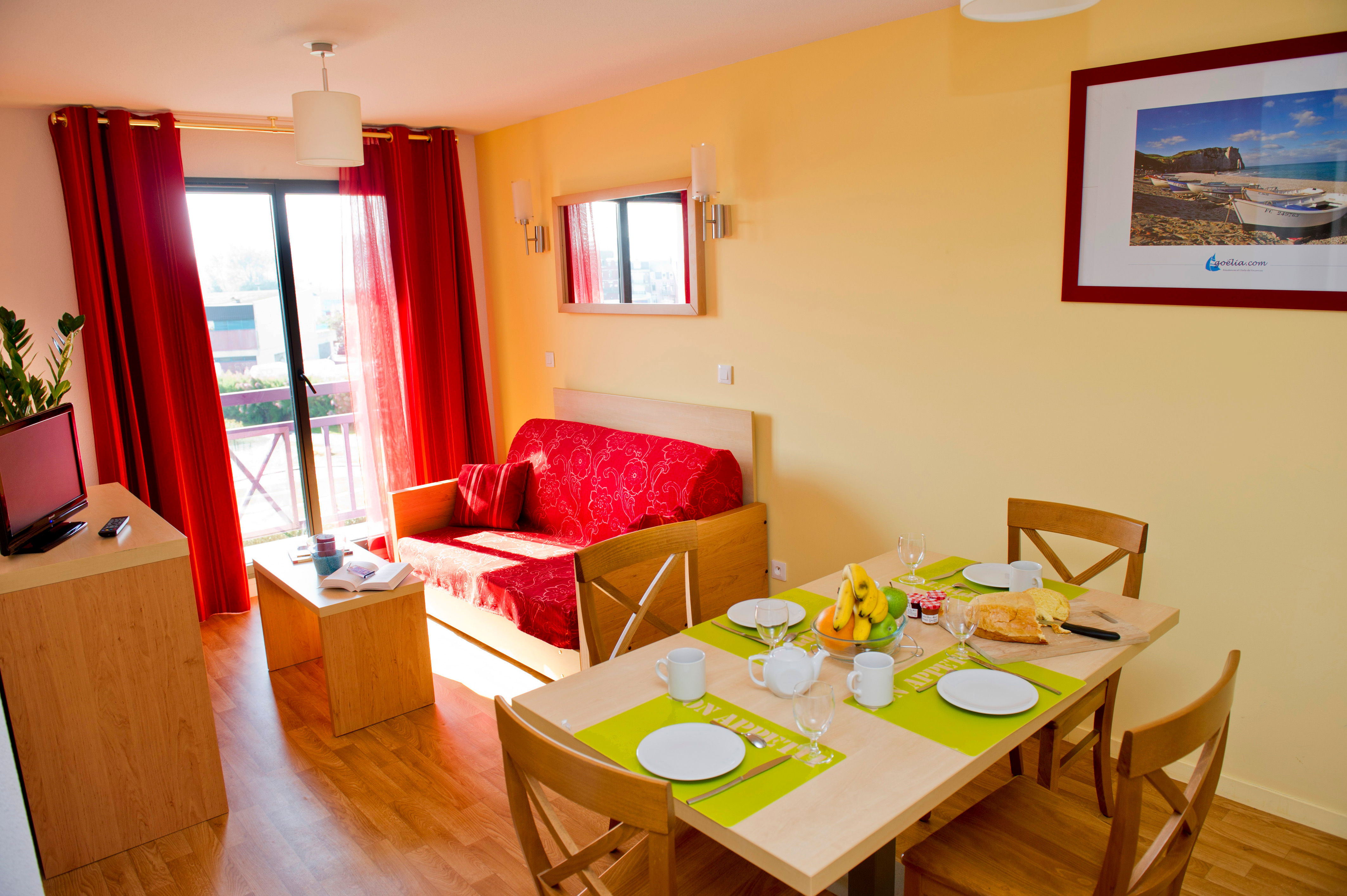 image Bright living area with a red sofa and wooden furniture, where you can relax after a day at the beach