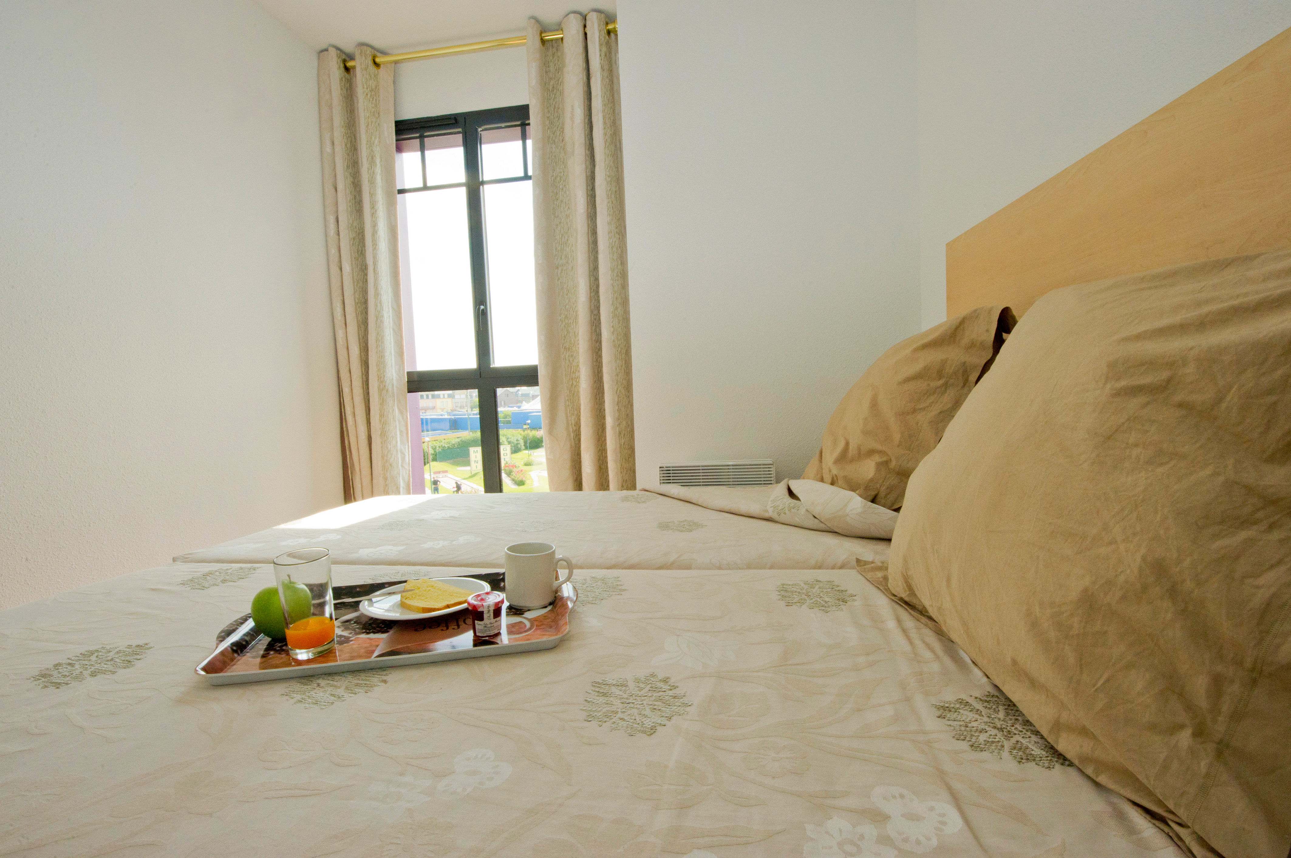 image Bedroom with two single beds and white linens — one of three bedrooms across the 60 m² apartment
