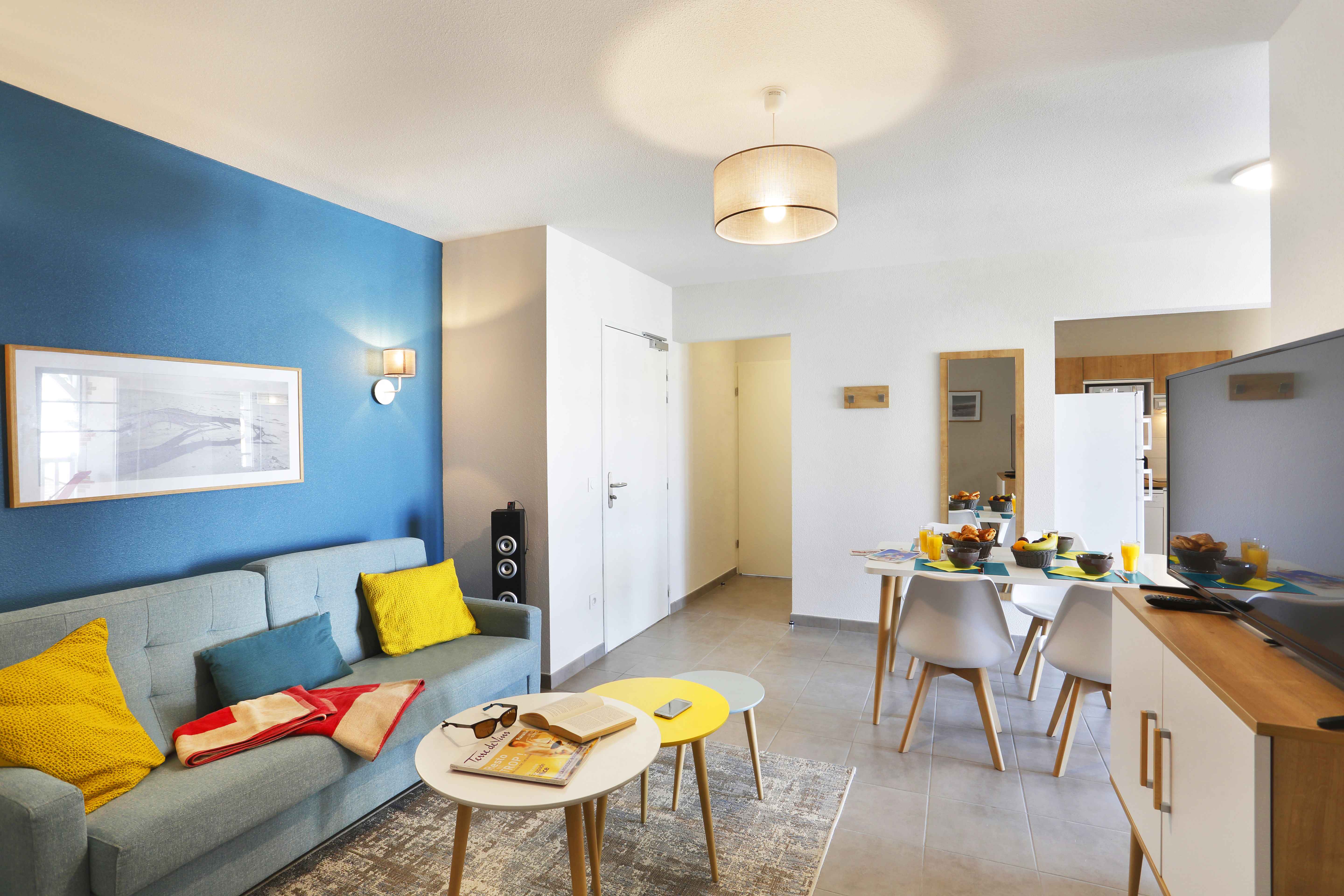 image Gather around the dining table for a delightful meal in this cheerful living space.