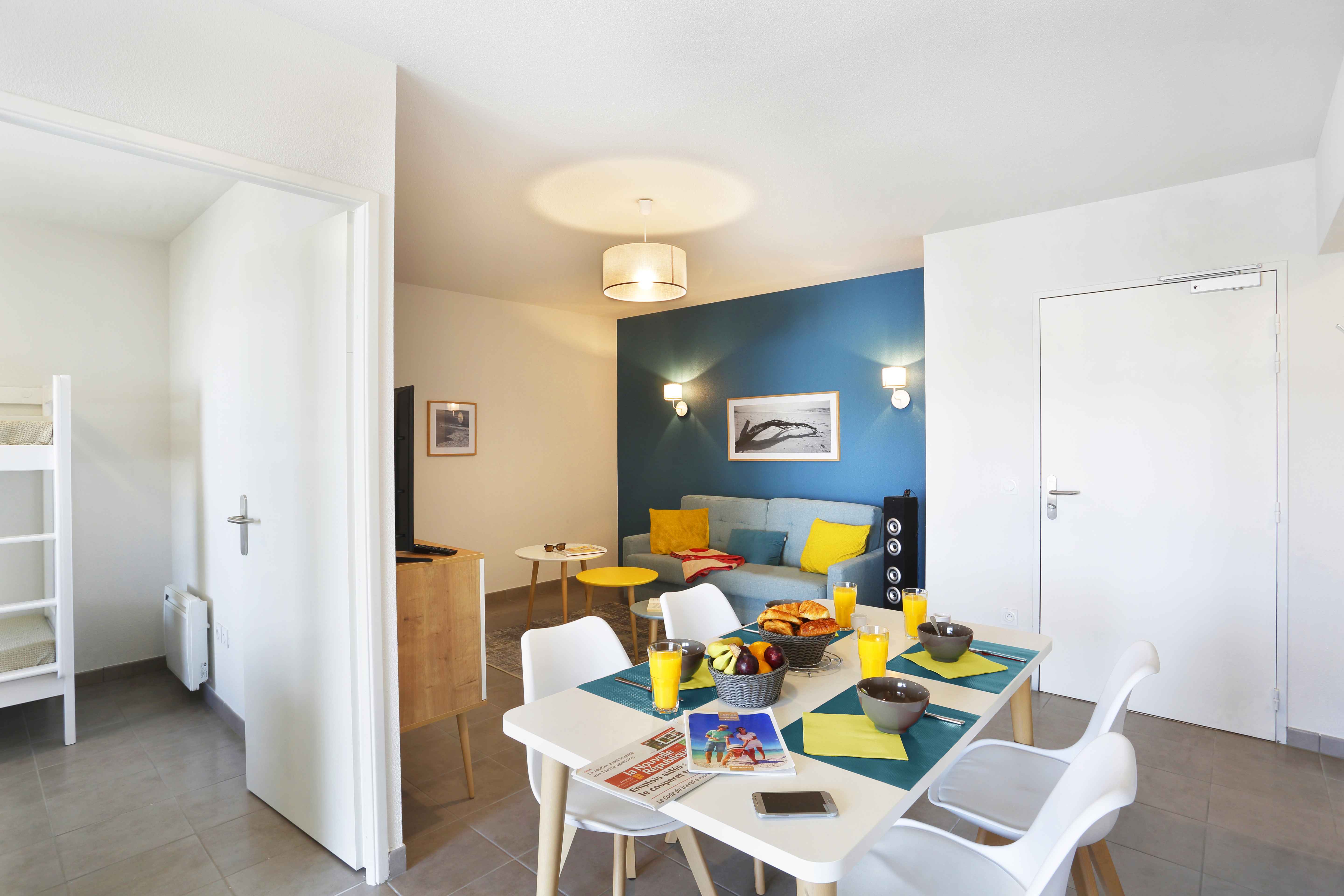 image Gather around the dining table, where bright accents and comfortable seating invite shared meals and laughter.