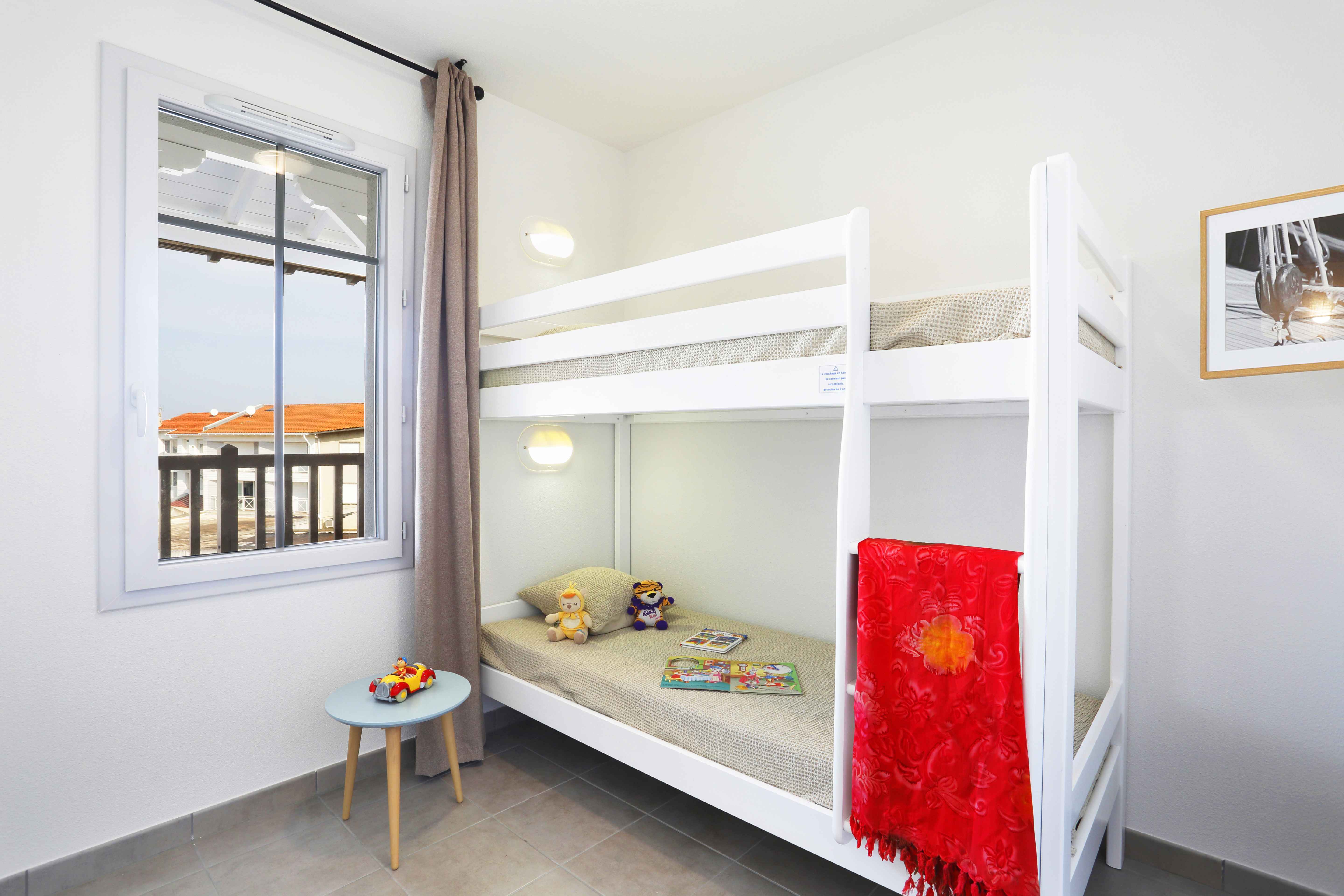 image The cozy bunk room is perfect for children, complete with playful decor and natural light.