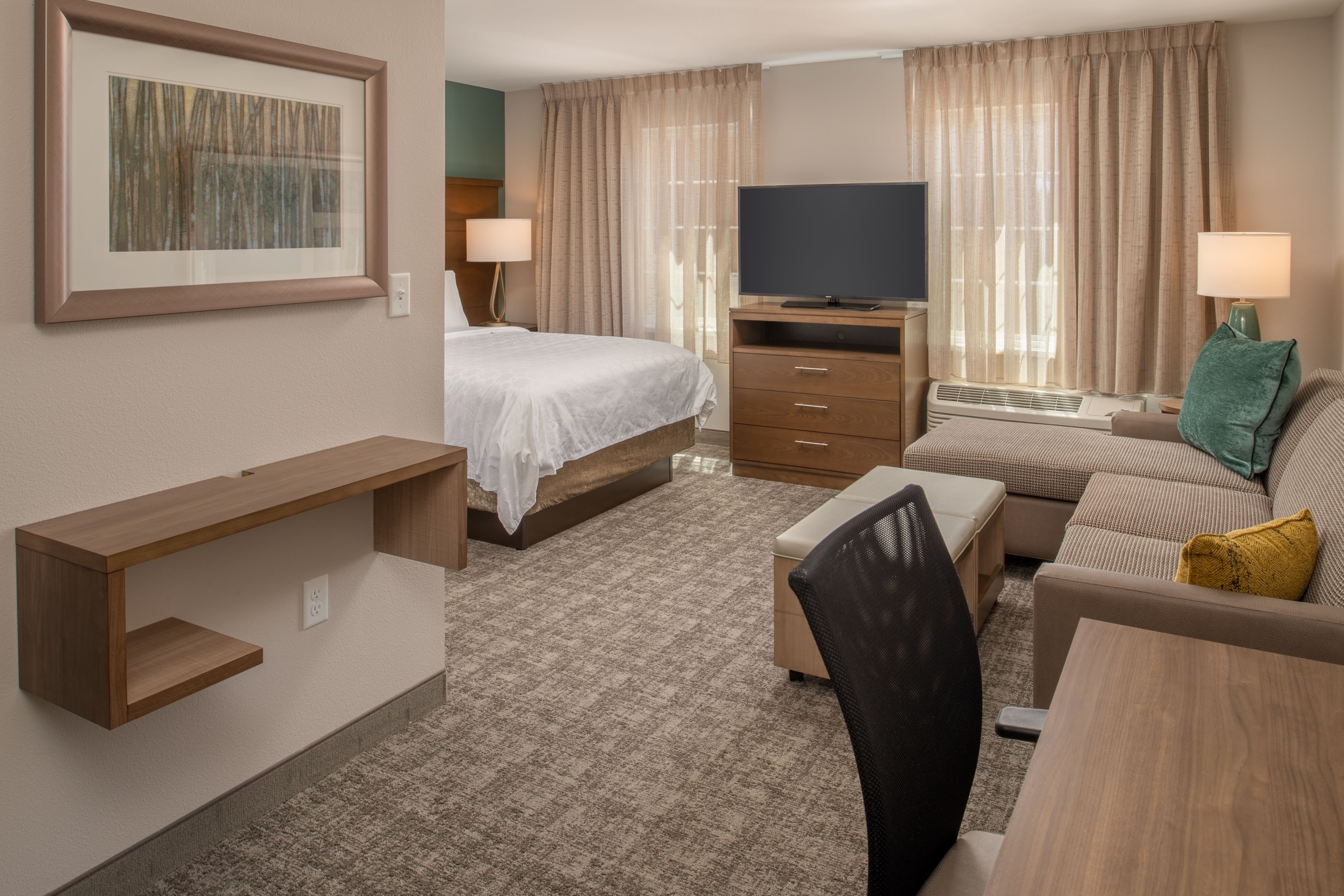 image Studio suite with queen bed, seating area, and flat-screen TV.