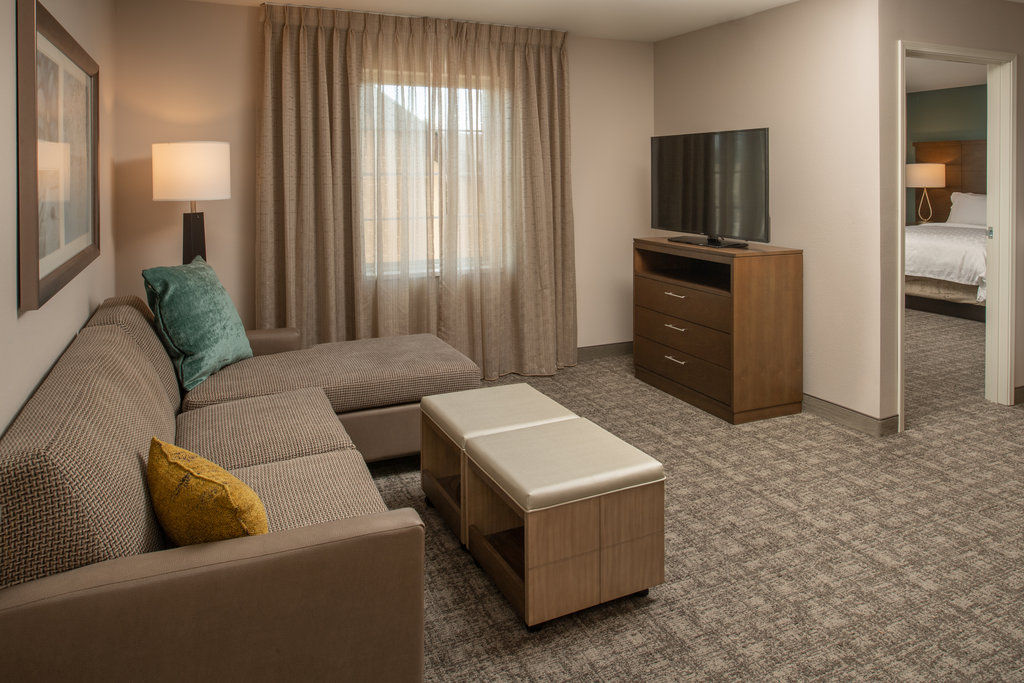 image Living area with sofa, flat-screen TV, and dresser.