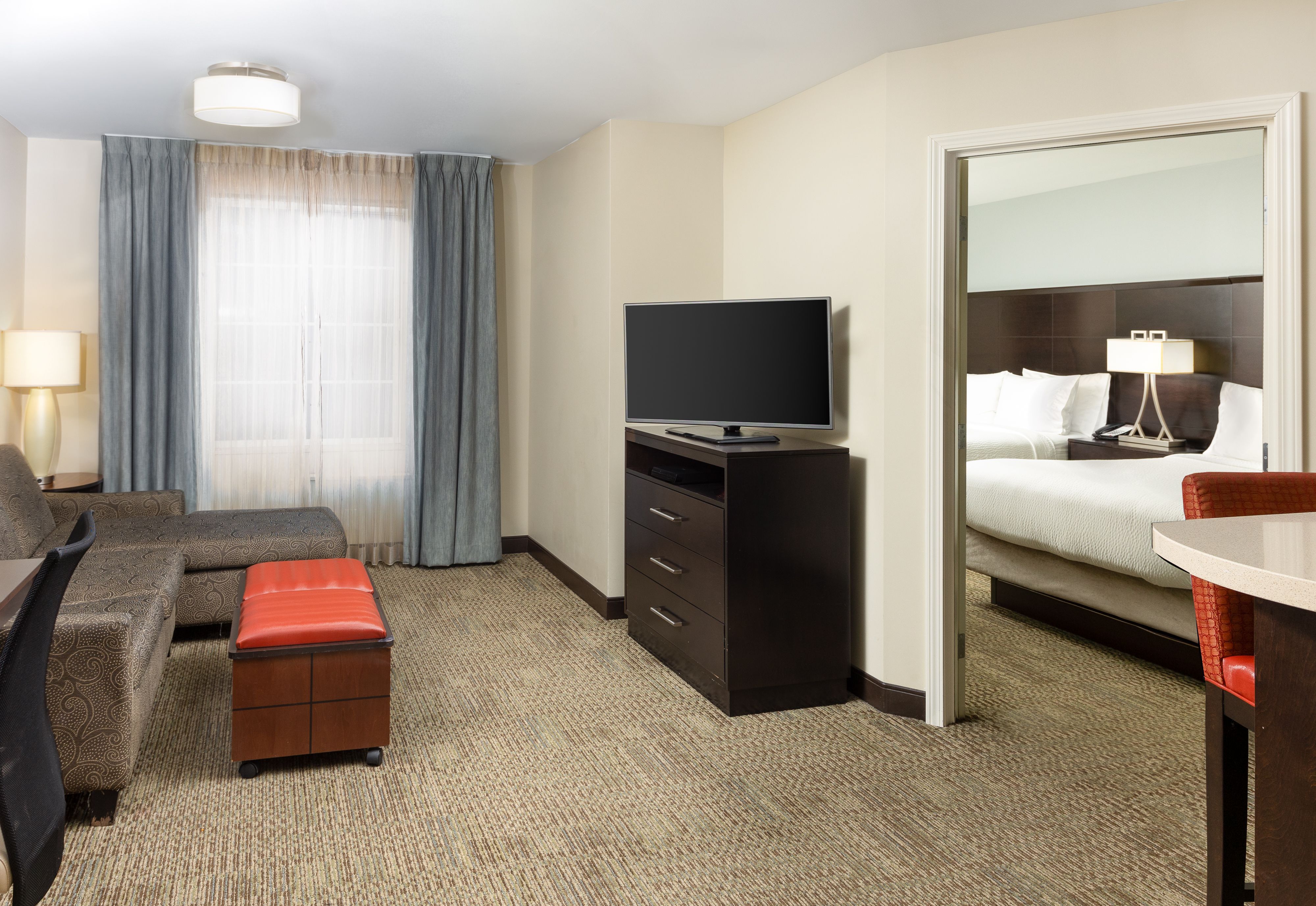 image Living area with seating, TV, and bedroom view.