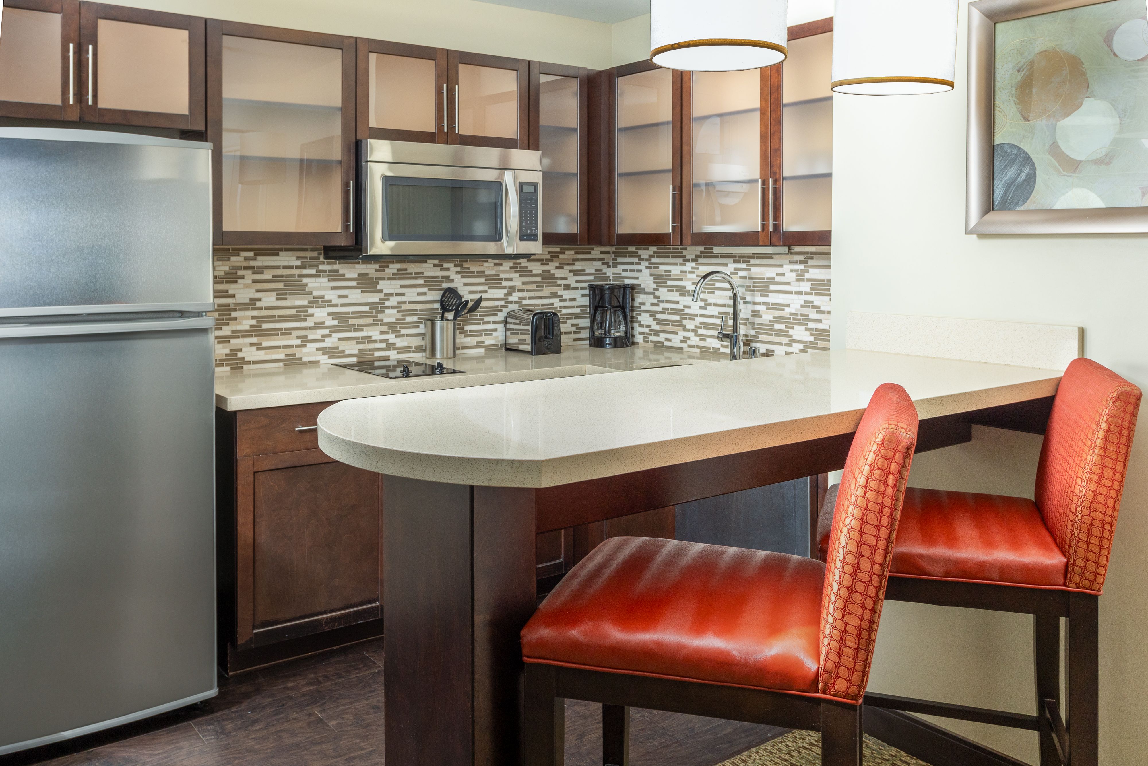 image Fully equipped kitchen with modern appliances and counter seating.