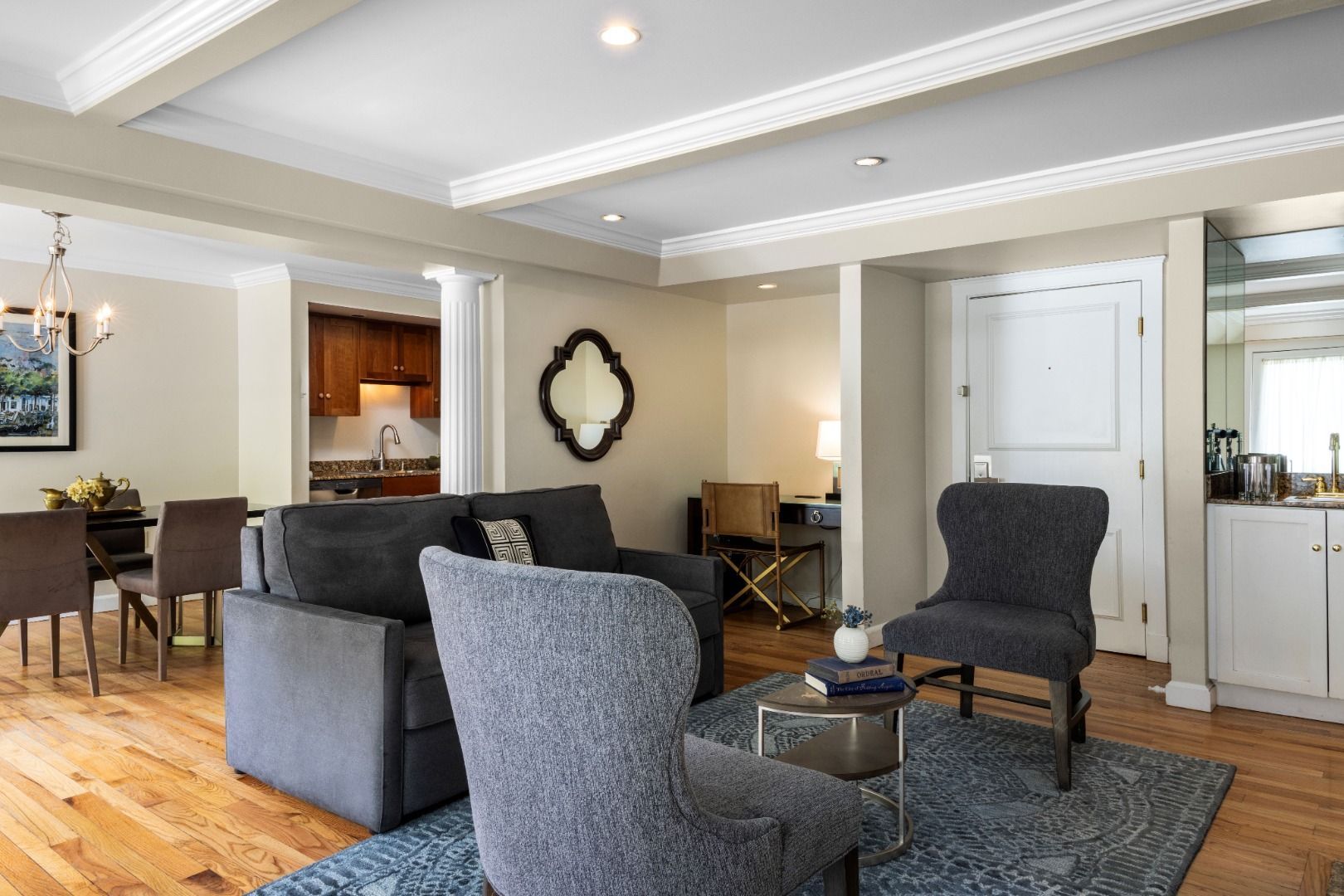 image This inviting space combines a stylish seating area with a graceful dining nook, accentuated by tasteful decor and warm wood flooring for a truly cozy retreat.