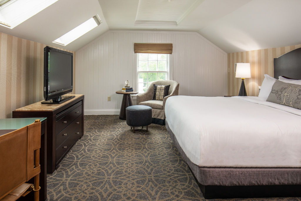 image Nestled in the comfort of this bedroom, guests will find a serene escape, complete with plush bedding and a quaint workspace.