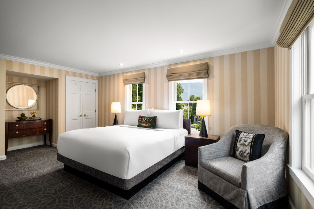 image Stylish and spacious bedroom with a comfortable seating area for reading or relaxation.