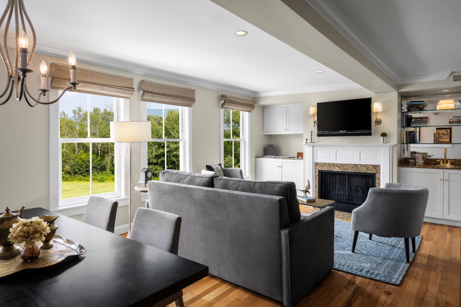 image The spacious living area boasts modern furnishings, a captivating fireplace, and abundant natural light streaming in through multiple windows, creating a welcoming retreat for relaxation.