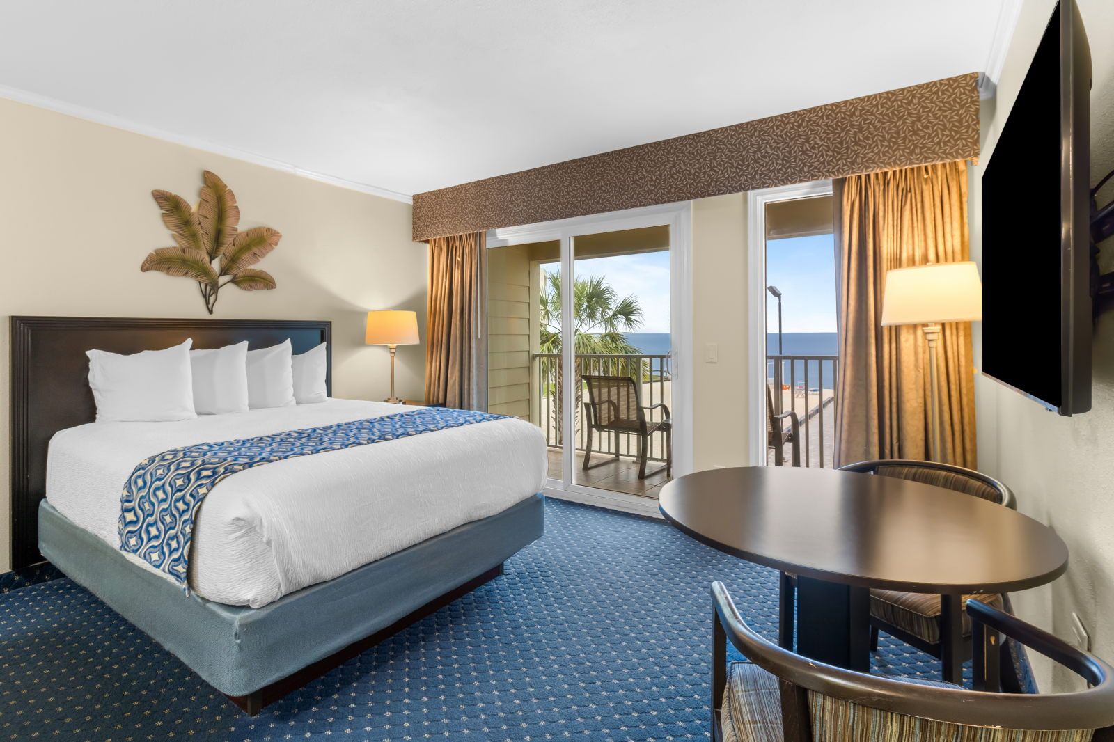 image A bright and comfortable suite awaits you, with a view to the balcony and inviting seating.