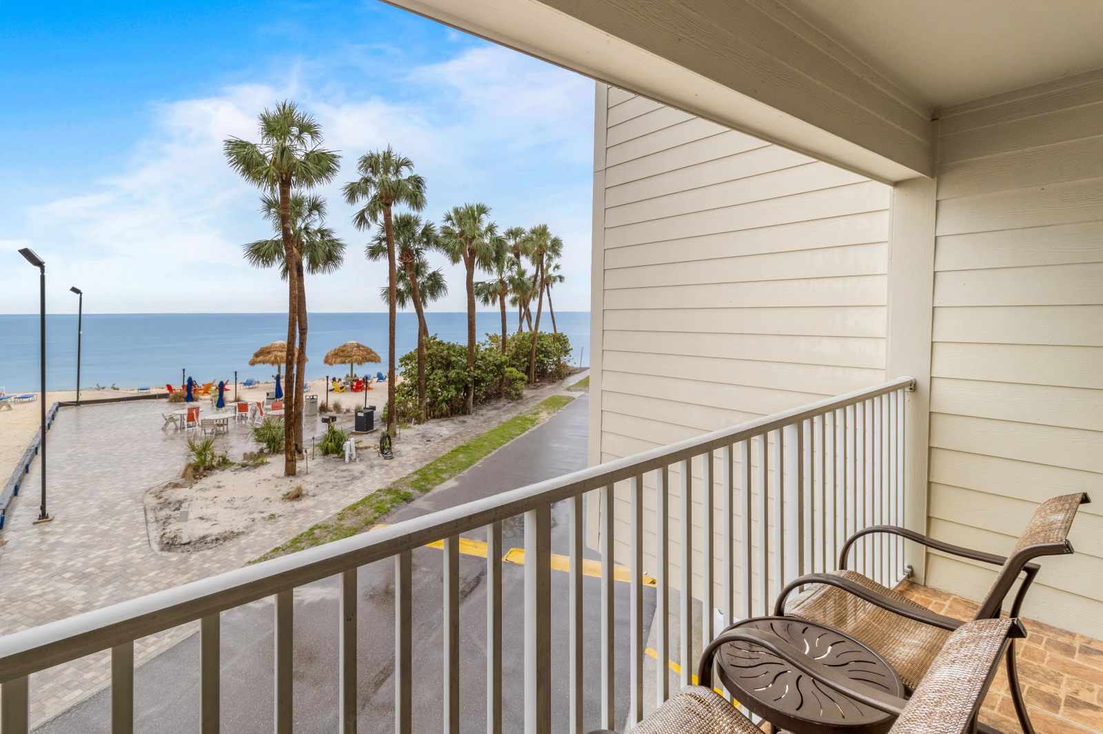image Enjoy morning coffee on your private balcony with views of palm trees swaying by the beach.