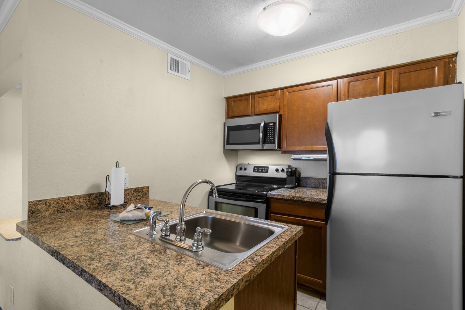 image Cook with ease in this modern kitchen, complete with full appliances and sleek countertops.