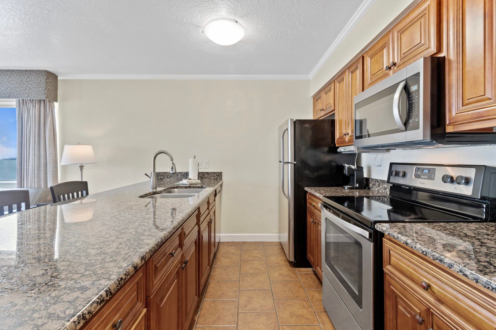 image Cook up your favorite meals in this modern kitchen, surrounded by rich wood cabinetry and sleek appliances.