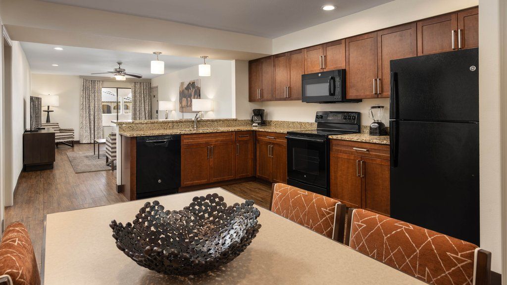 image Fully equipped kitchen layout, showcasing sleek appliances and a dining table ready for meals shared together.