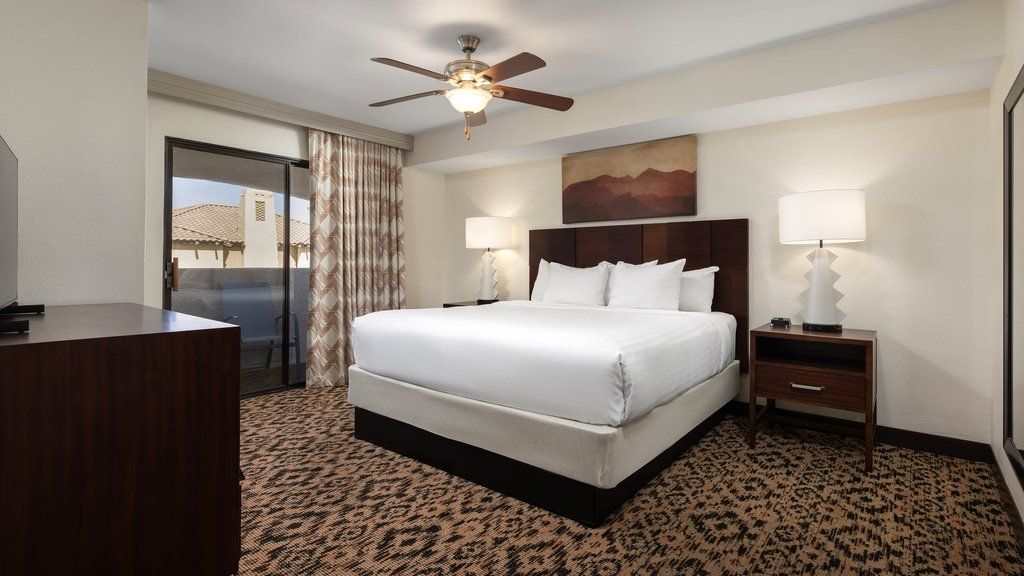 image Cozy king bedroom featuring soft linens and a private balcony, perfect for enjoying morning coffee.