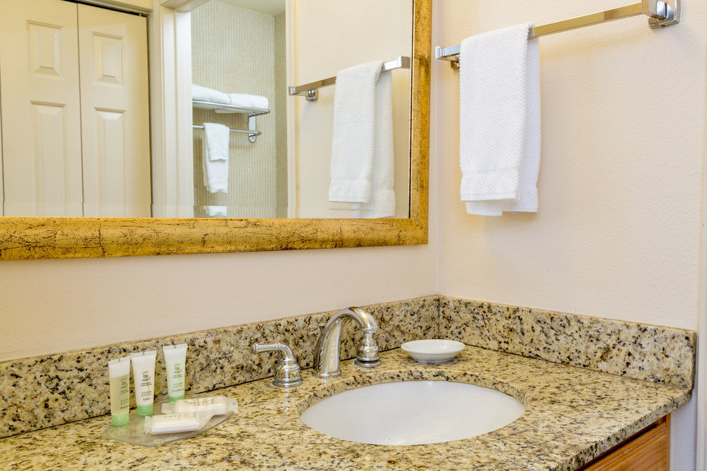 image Relax in a well-appointed bathroom featuring granite countertops and soothing natural light.
