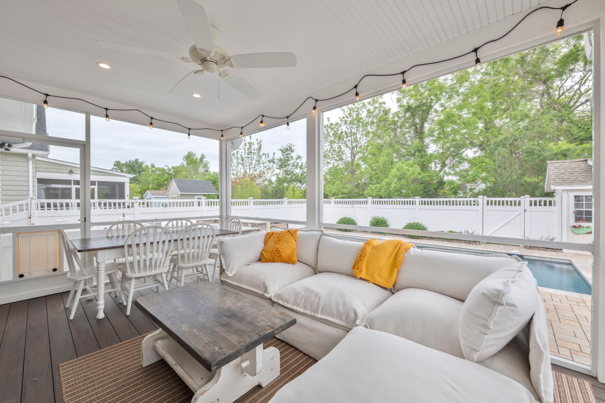 image Enjoy sunset views from the inviting screened porch, with plush seating and a rustic dining table.