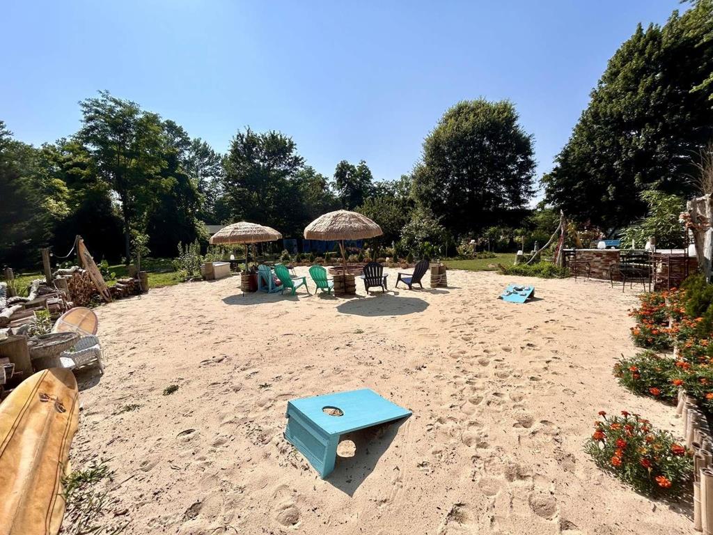 image Backyard outdoor area with thatched umbrellas, cornhole, and shaded seating.
