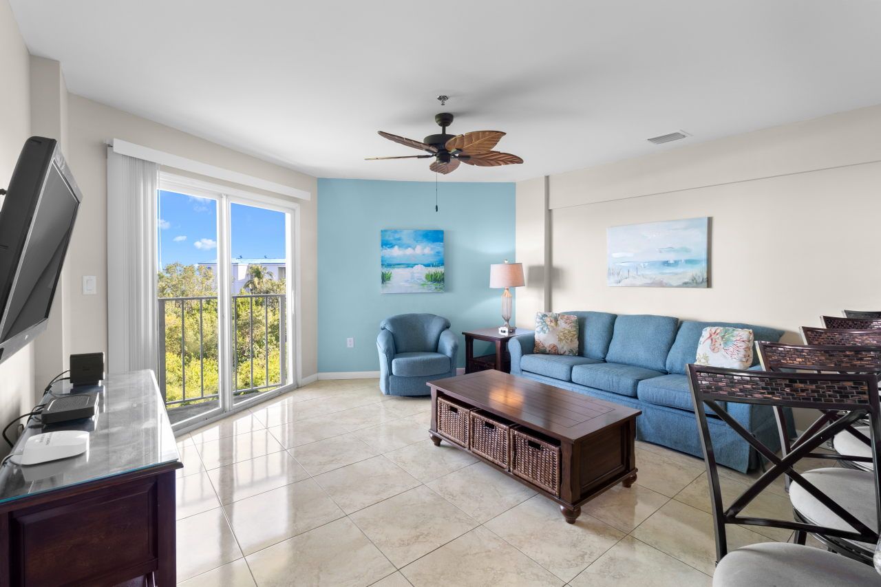 image Relax in the inviting living area, featuring a cozy couch and tasteful decor, with views peeking through the windows.