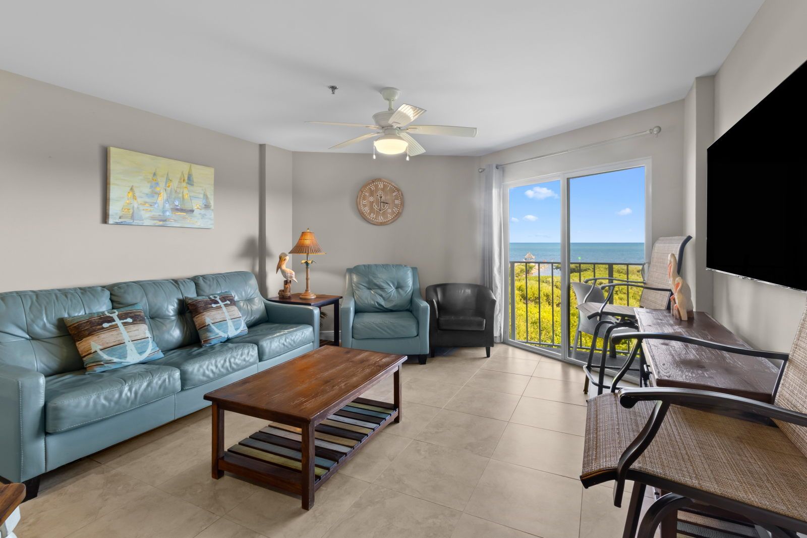 image Relax in a cozy living space with plush seating and ocean views just beyond the glass doors.