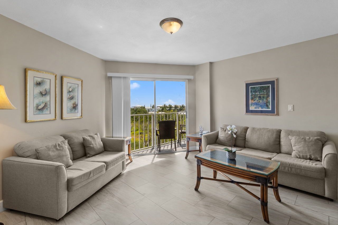 image Embrace comfort in this spacious living room, where cozy seating meets refreshing daylight from the balcony.