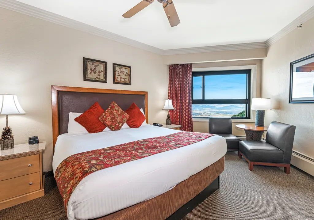 image Floor-to-ceiling windows frame the mountain treeline from the king bed.