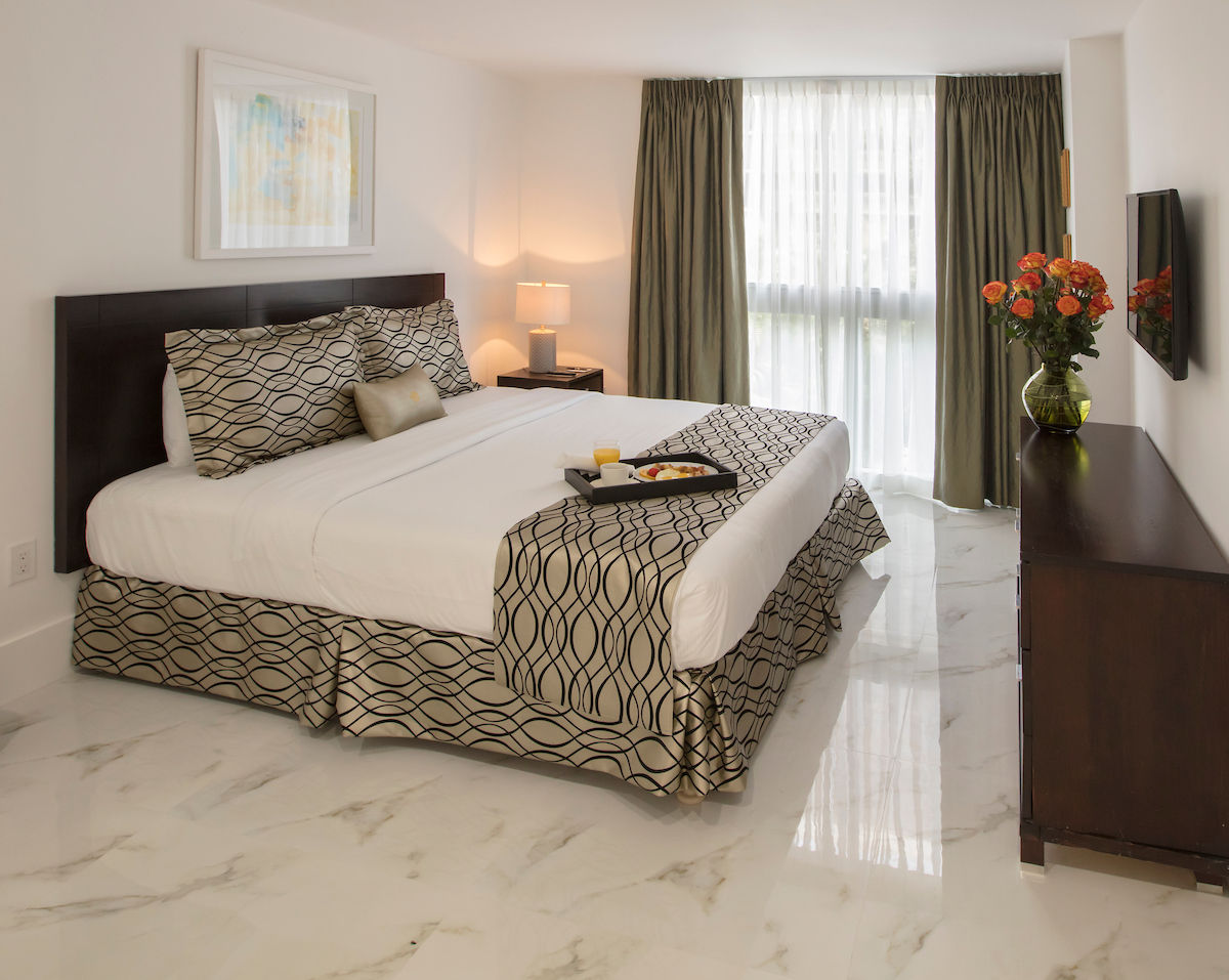 image Relax in a bright master bedroom with a plush king bed, perfect for peaceful nights.