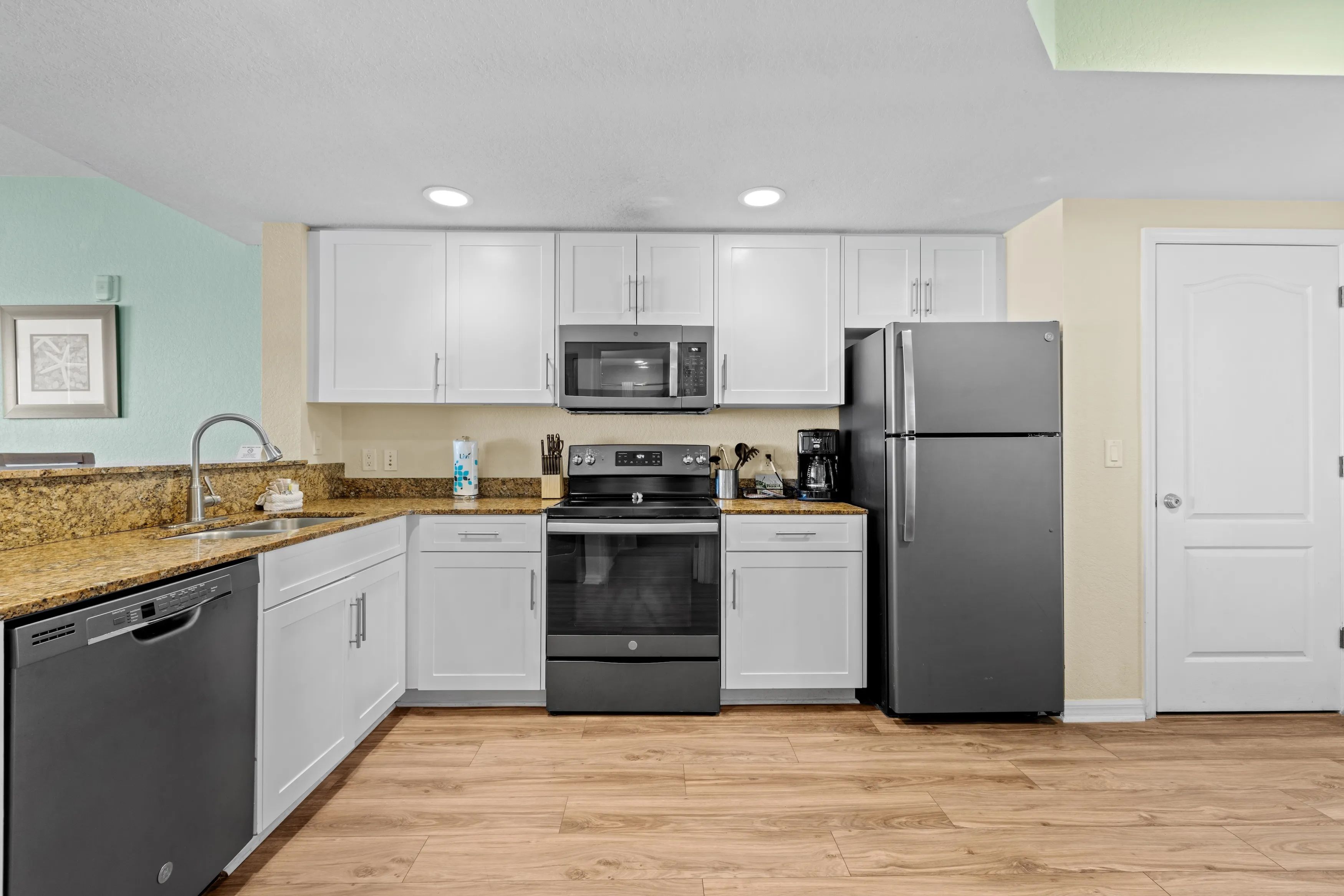 image Experience culinary convenience in this well-equipped kitchen featuring sleek appliances and granite countertops.